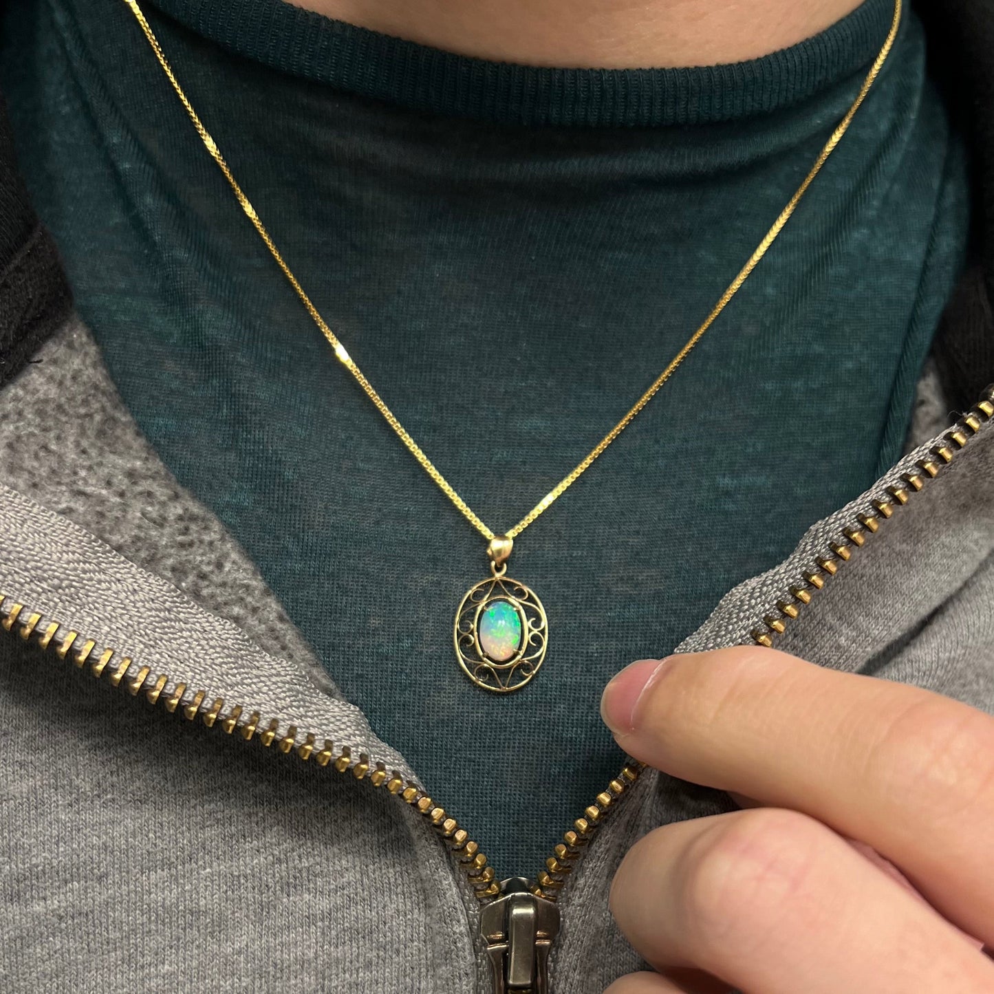 An 18 karat yellow gold filigree opal necklace. The opal has bright green color play.