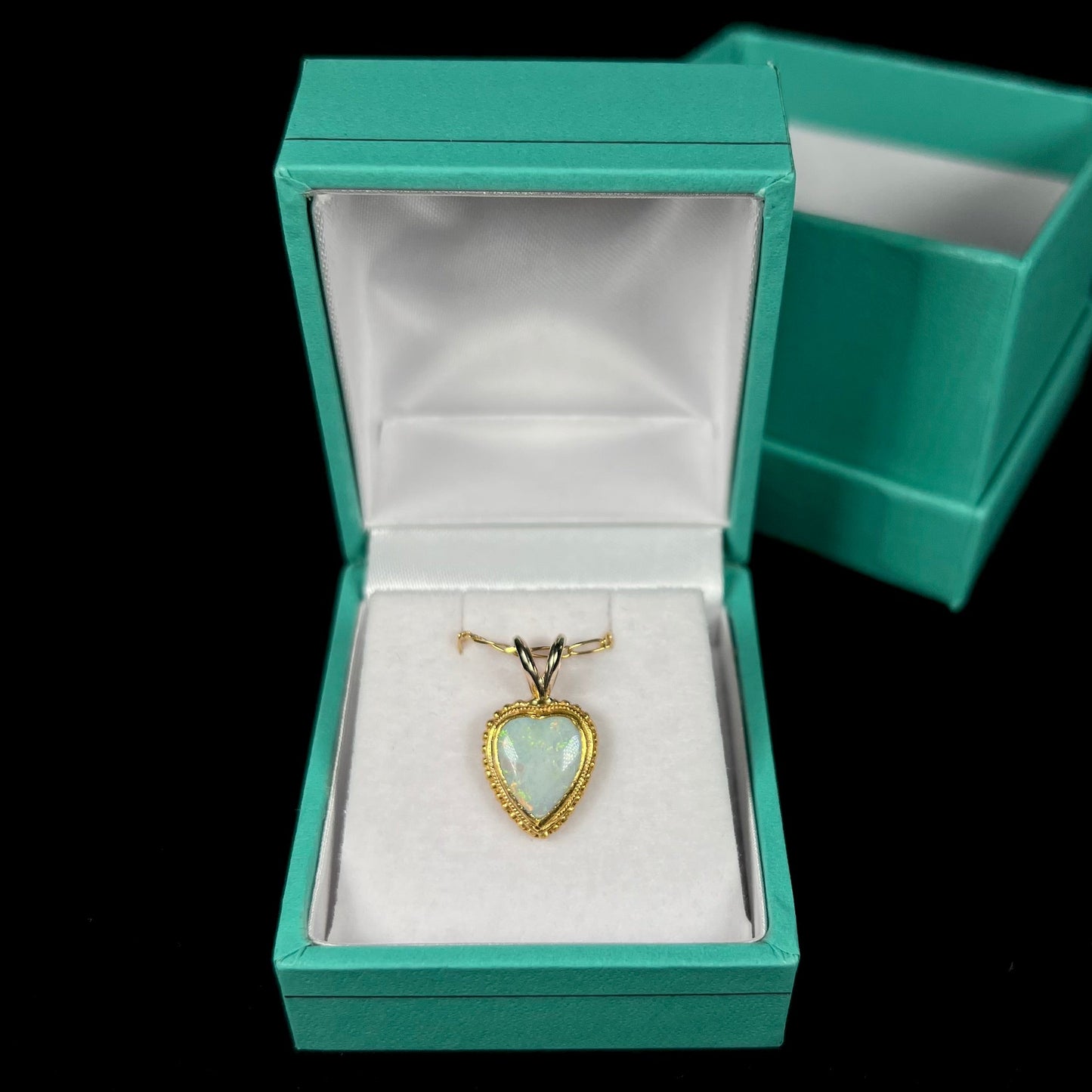 An 18 karat yellow gold heart necklace mounted with a heart shaped opal.