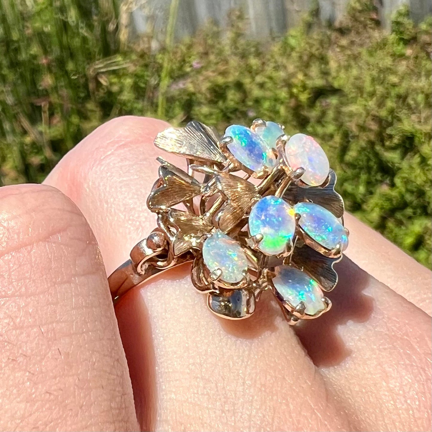 A ladies' vintage, modernist style opal cluster ring in yellow gold. The ring is tall with a high profile.