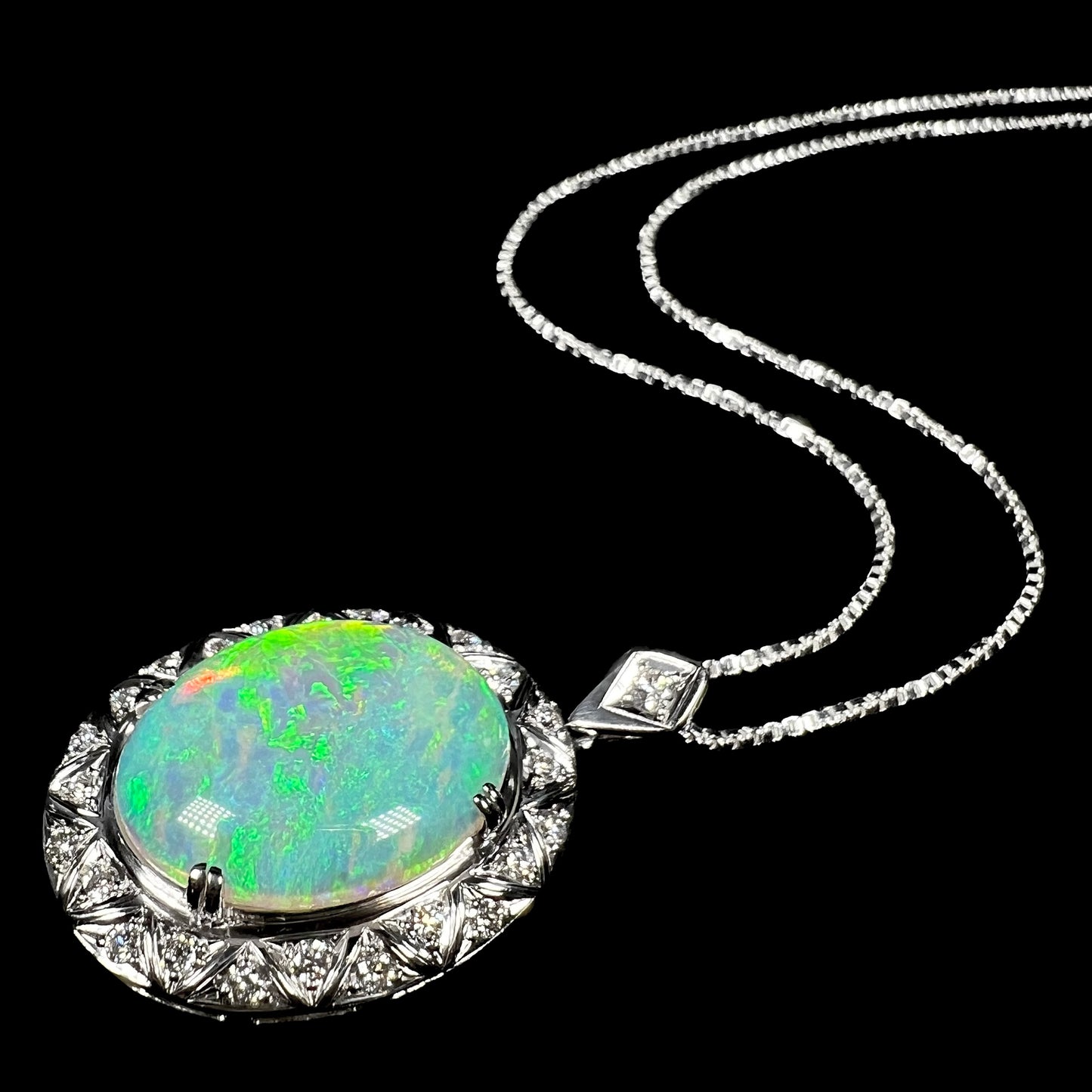 Stylized angled photo of Art Deco-inspired opal necklace lying flat on a black surface.