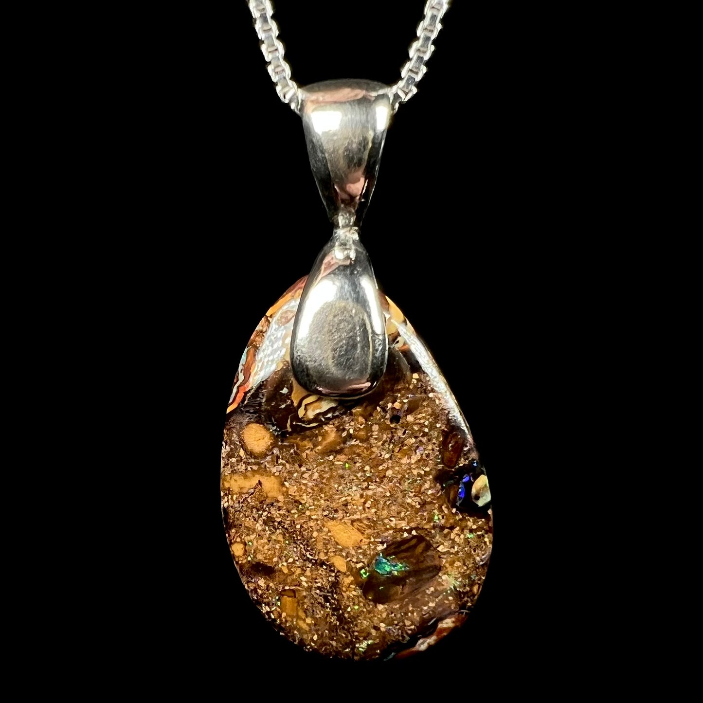Back side of an Australian boulder opal necklace with a sterling silver bail.