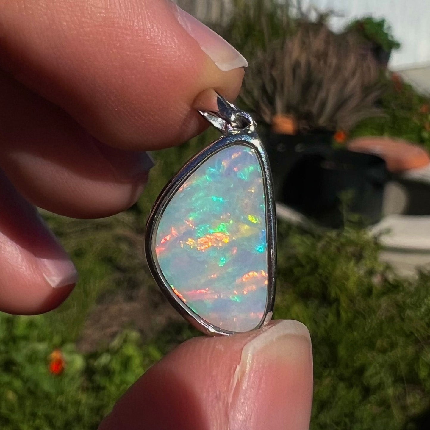 A sterling silver pendant bezel set with a white Australian crystal opal on a box chain.