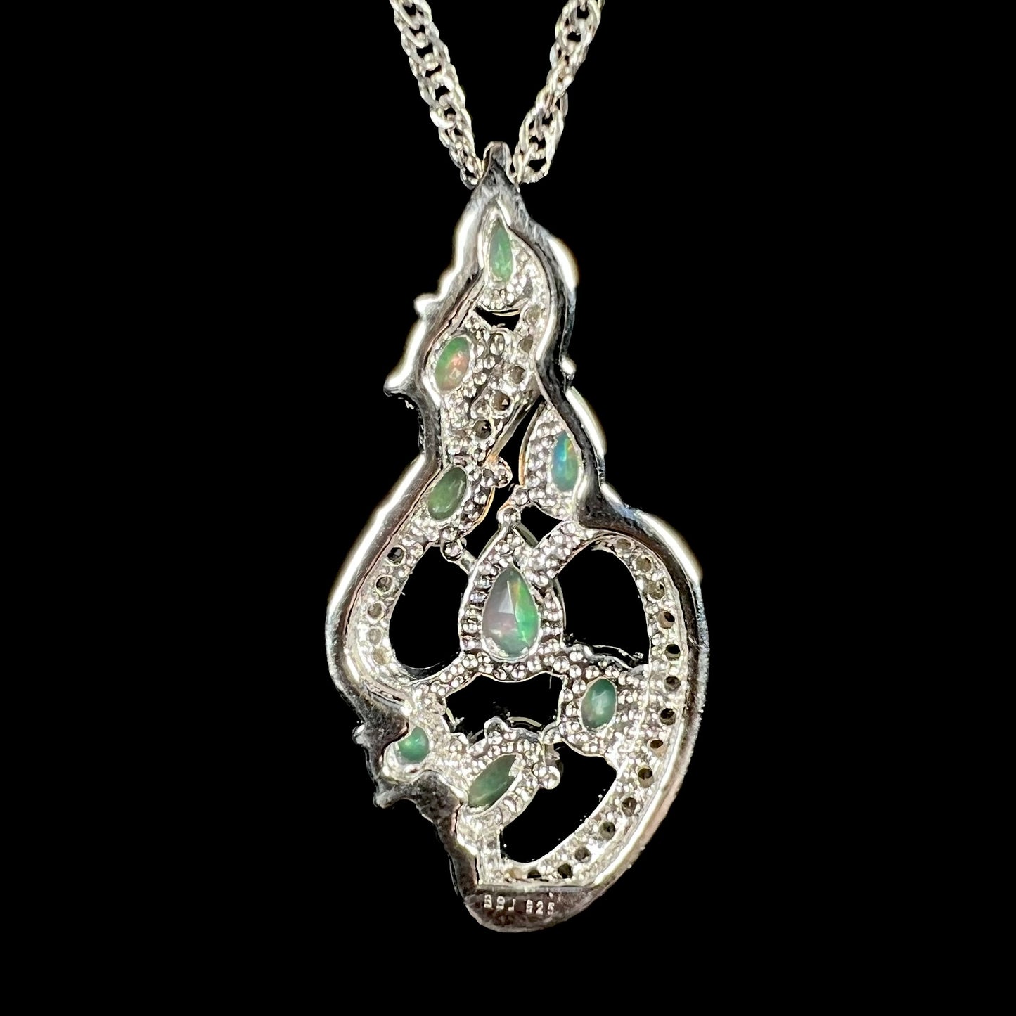 The back of a sterling silver Ethiopian opal necklace with an elegant design, shown on a black backdrop.
