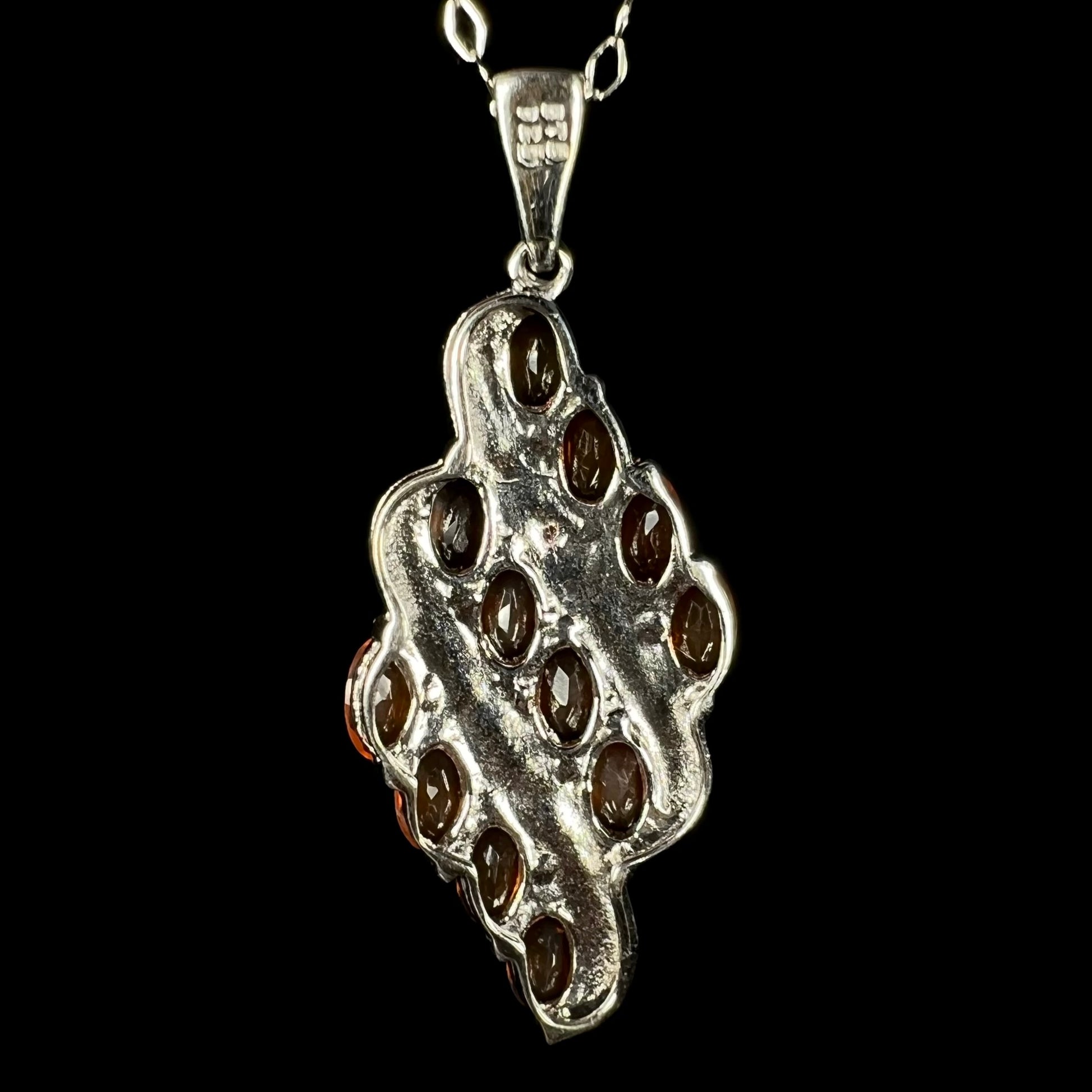 Back view of a silver necklace, set with Mexican fire opals that are not seen in the image.