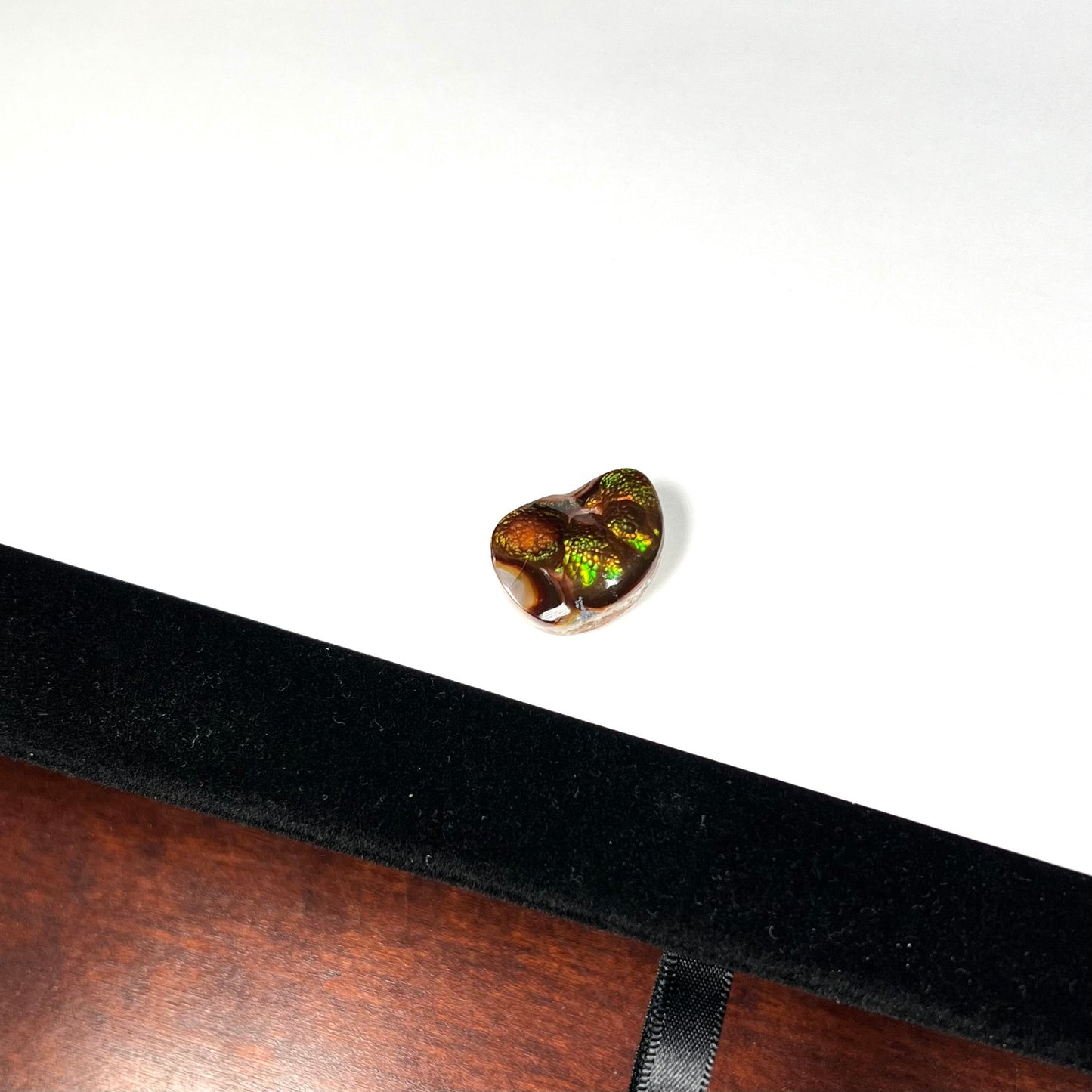 A large Mexican fire agate cabochon. The stone has a bubbly green pattern.