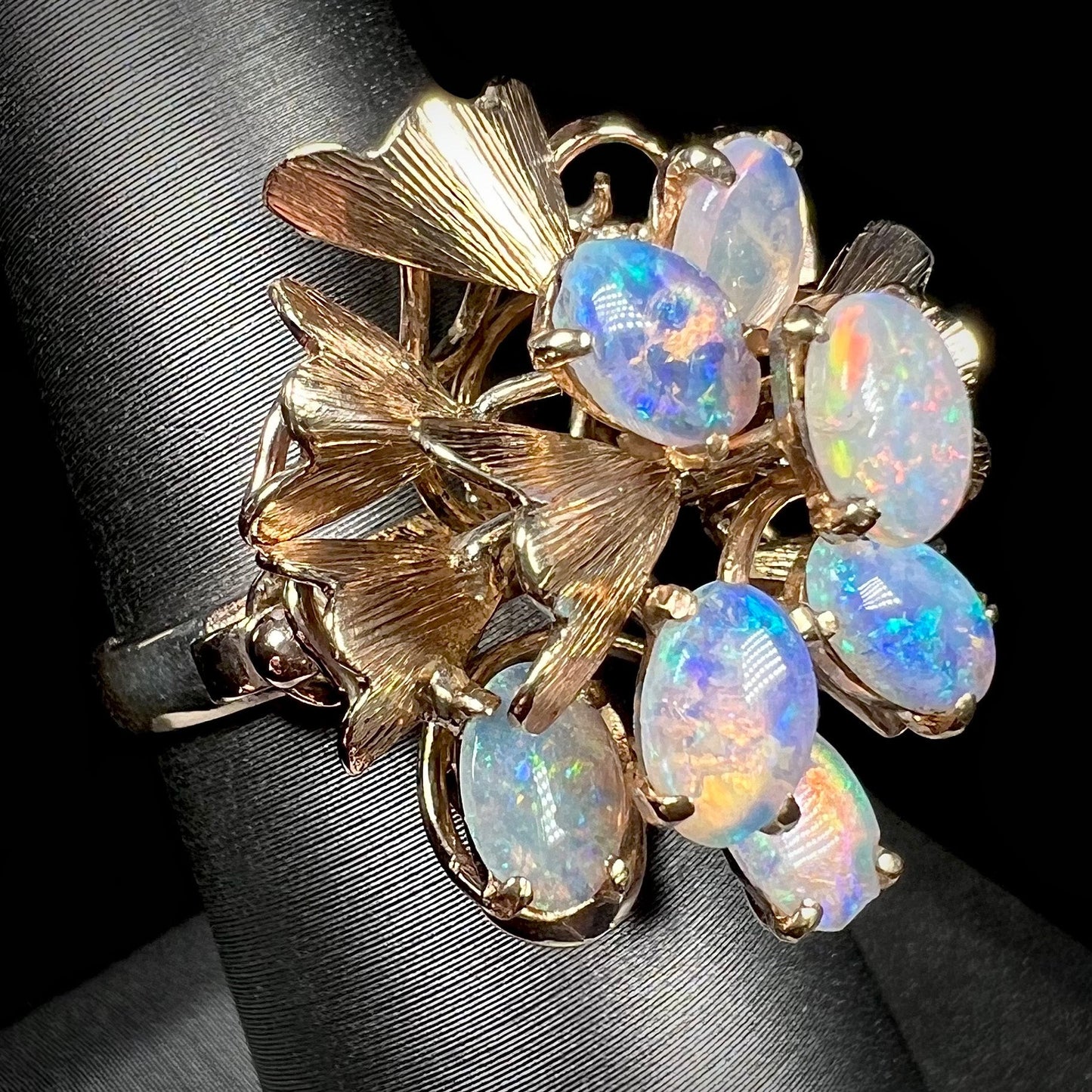 A ladies' vintage, modernist style opal cluster ring in yellow gold. The ring is tall with a high profile.