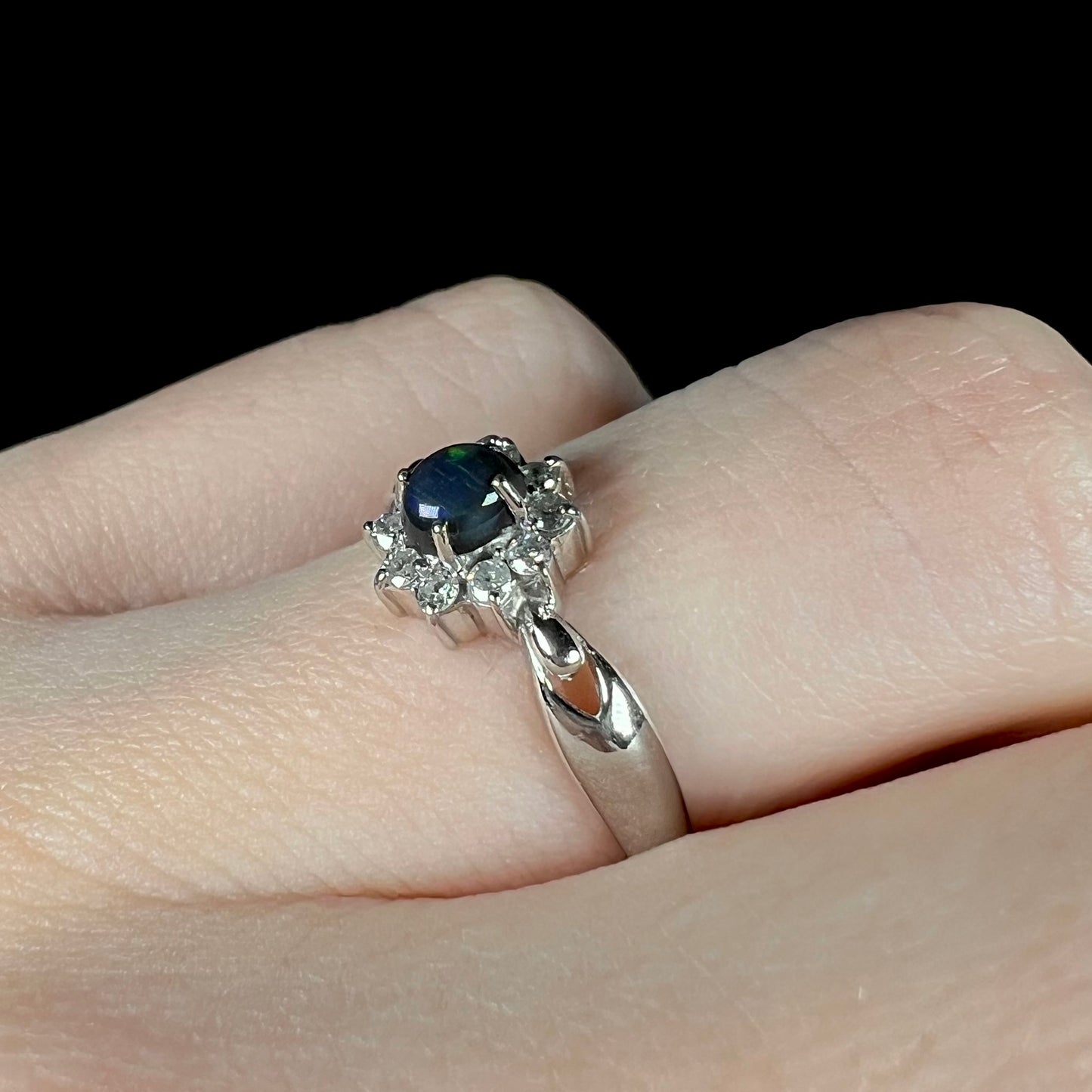 Angled macro view of black opal ring on hand with no visible color play.