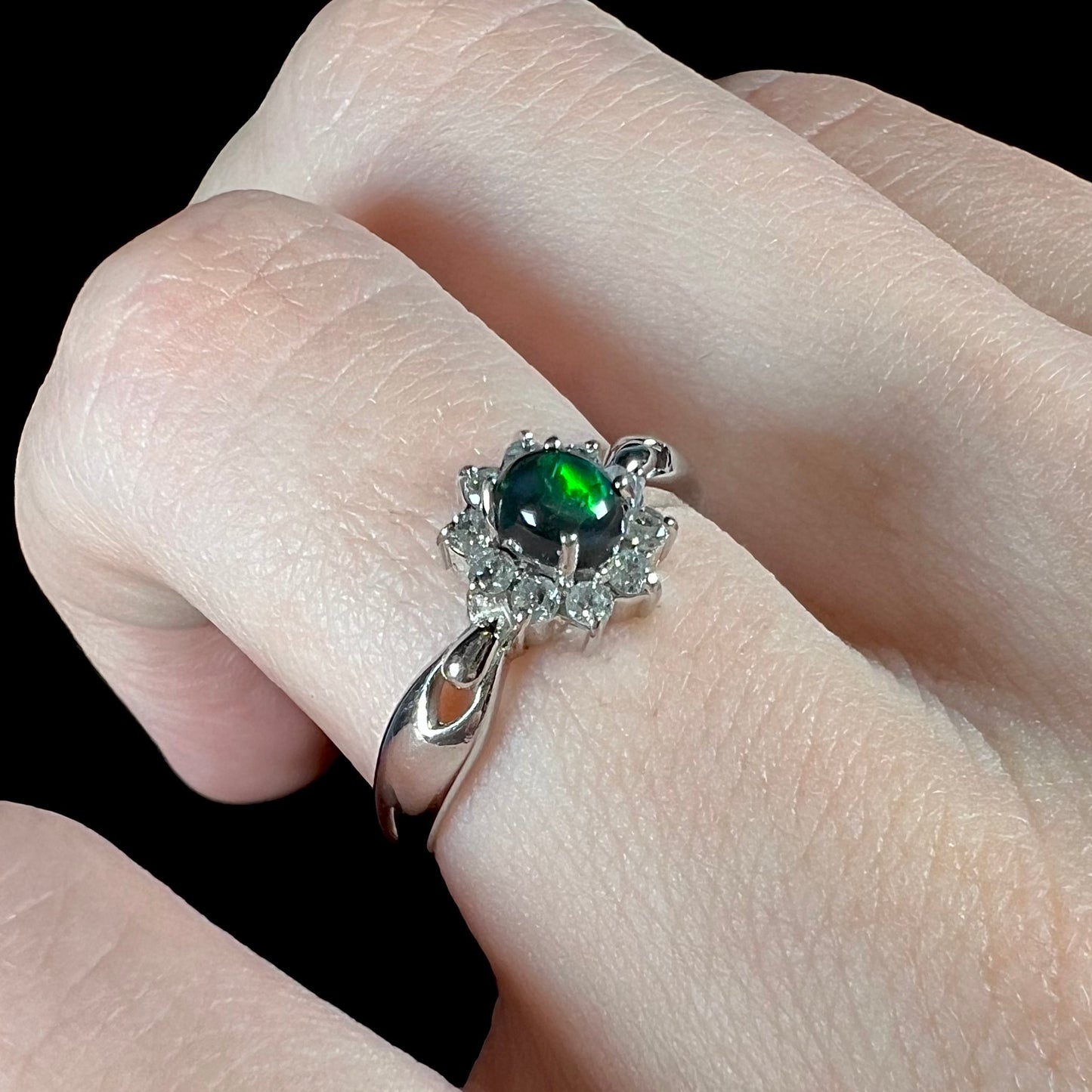 Angled view of opposite side of opal ring with visible green flash in opal.