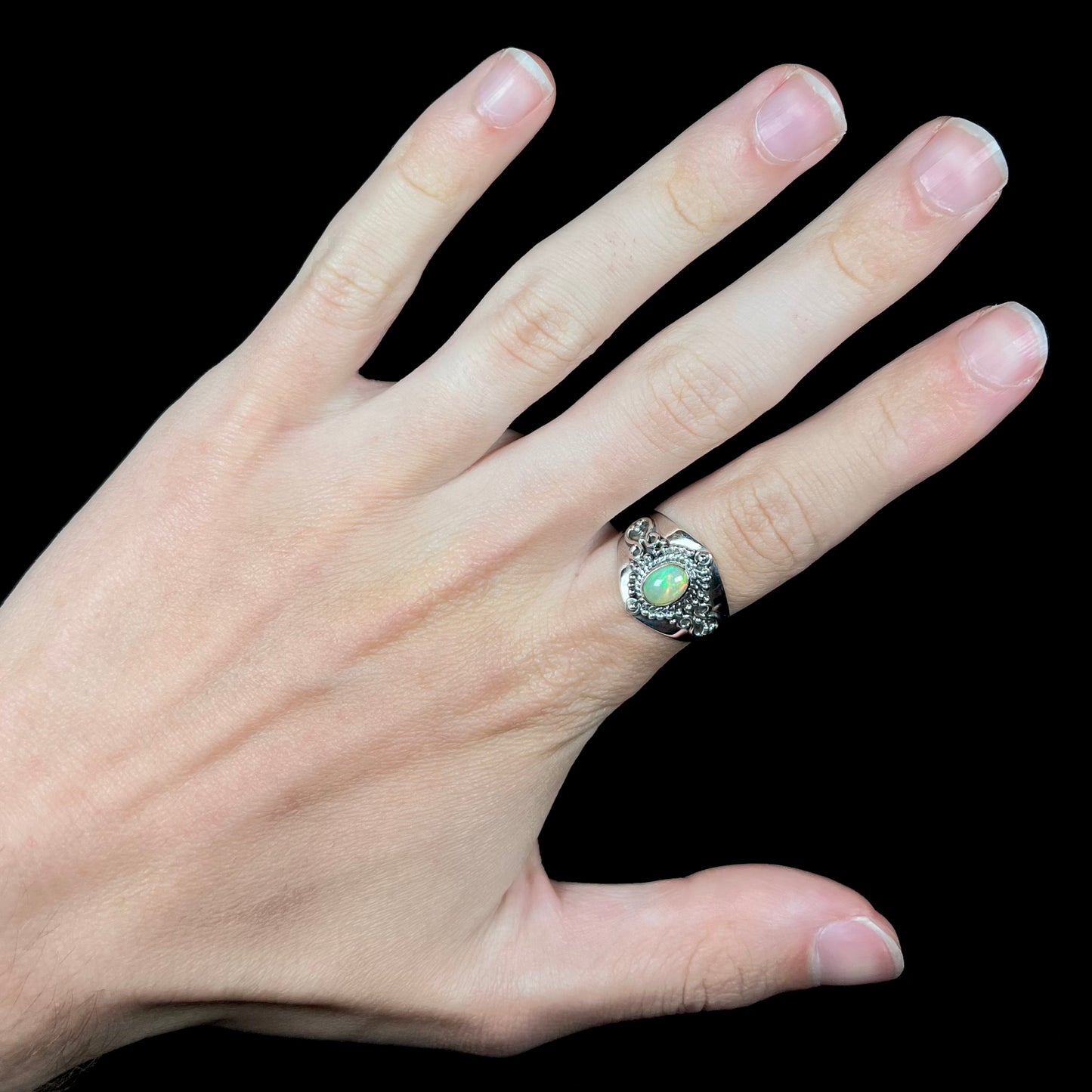A Boho-style men's opal ring made from sterling silver and Ethiopian opal, worn on a hand.