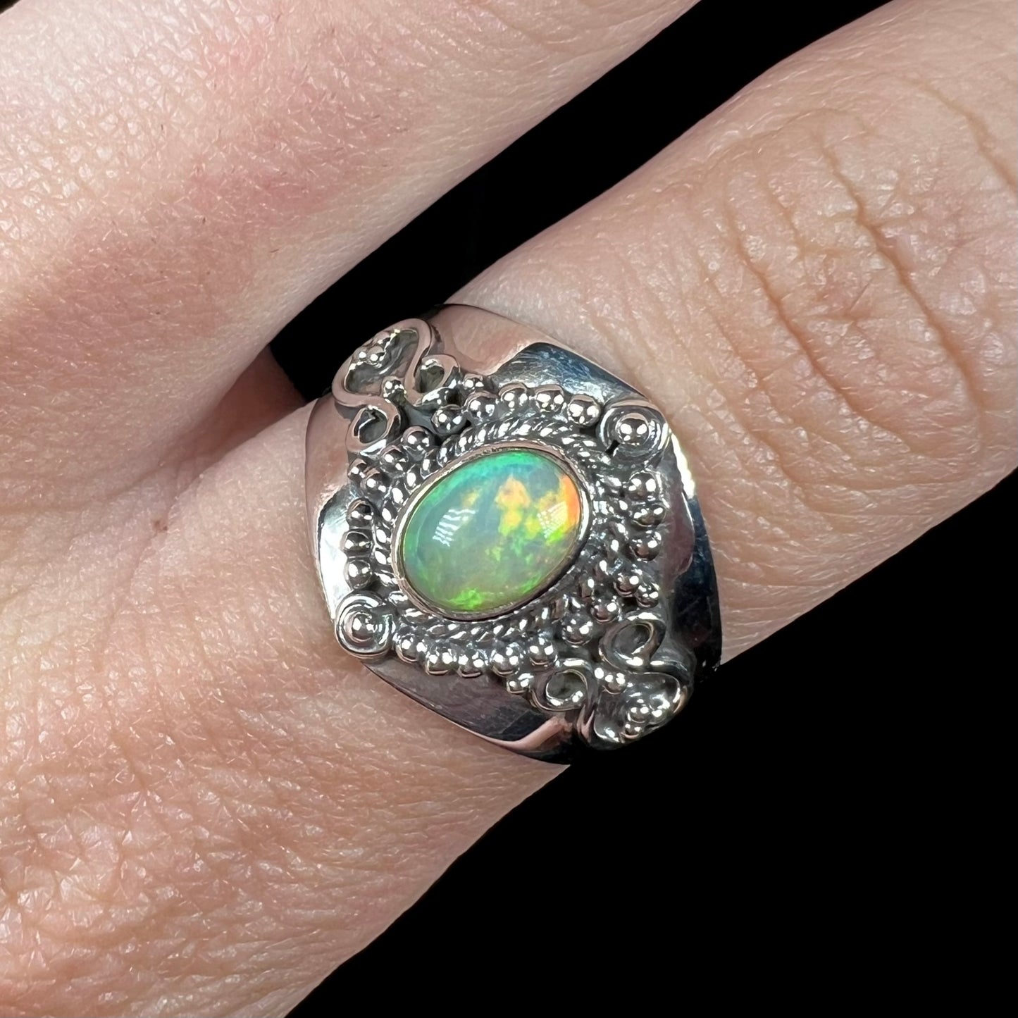 A Boho opal ring shown close-up on a finger from the front view.