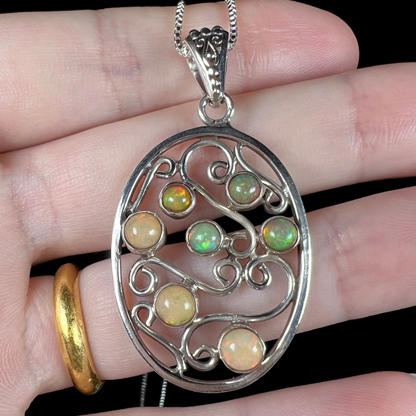 A Boho-style Ethiopian opal necklace shown in a hand close-up.