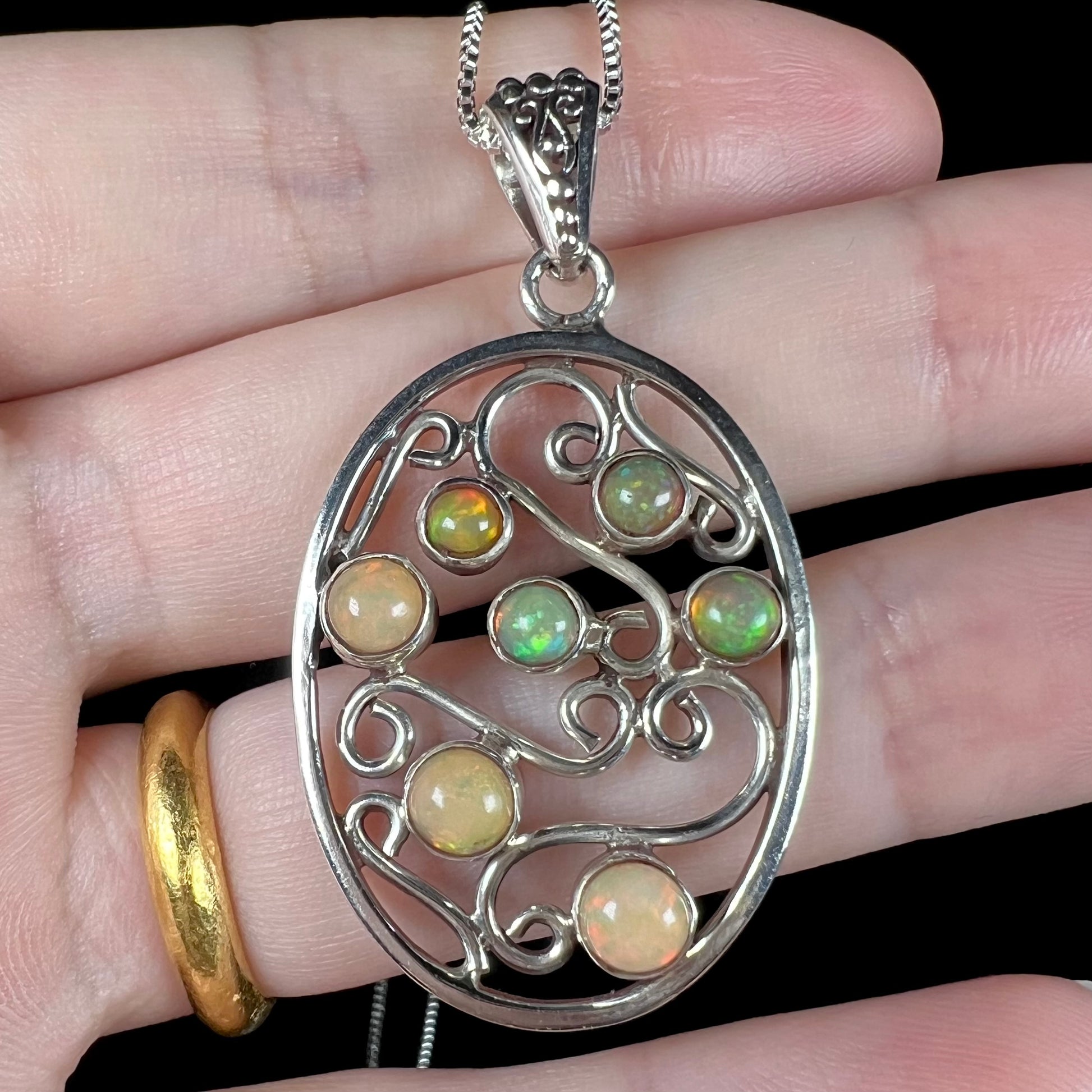 A Boho-style Ethiopian opal necklace shown in a hand close-up.