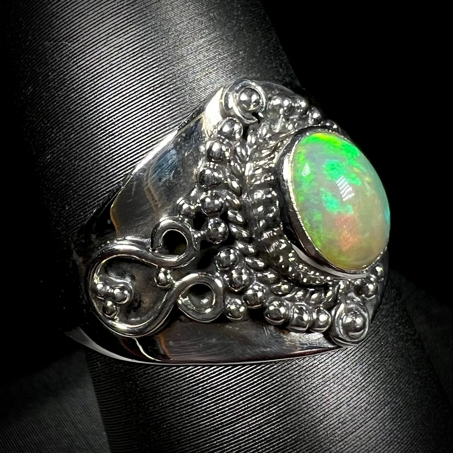 A sterling silver, boho-style opal ring, shown from an angle.