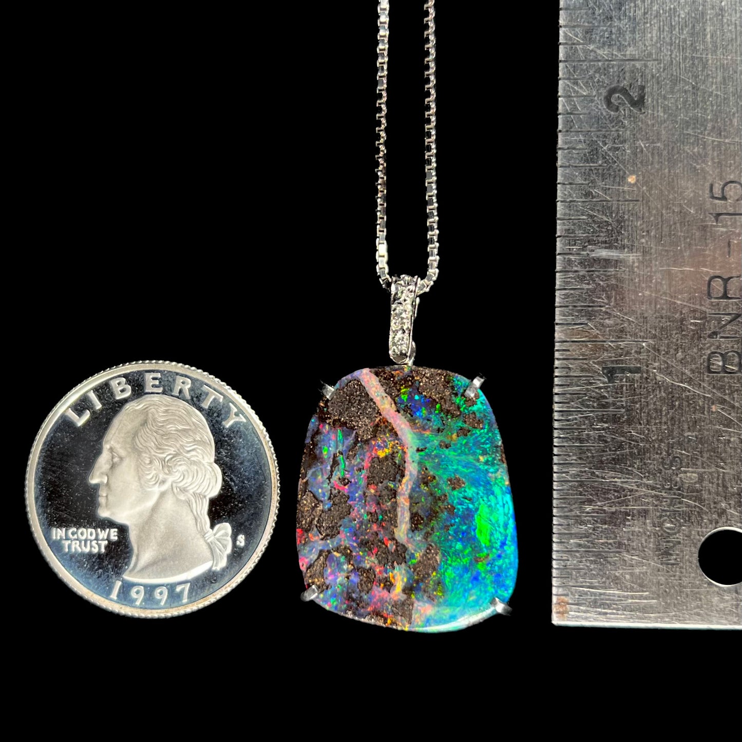 Boulder opal necklace with a quarter and ruler for scale, measuring approximately 1.25 inches from the top of the bail.