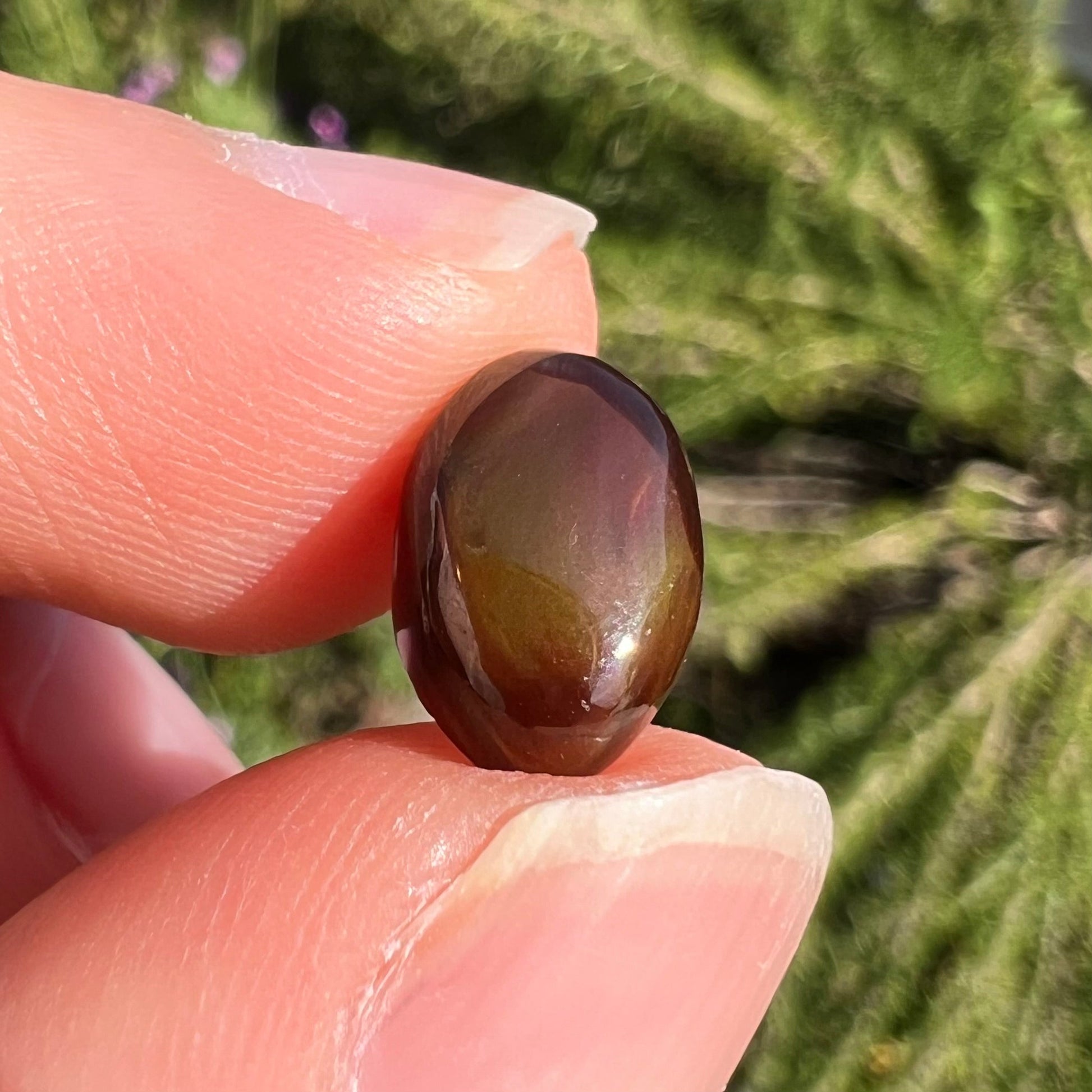 A loose, 3.38ct, pear shaped Mexican fire agate stone.  The stone shines a vivid, bright green color with a purple streak.