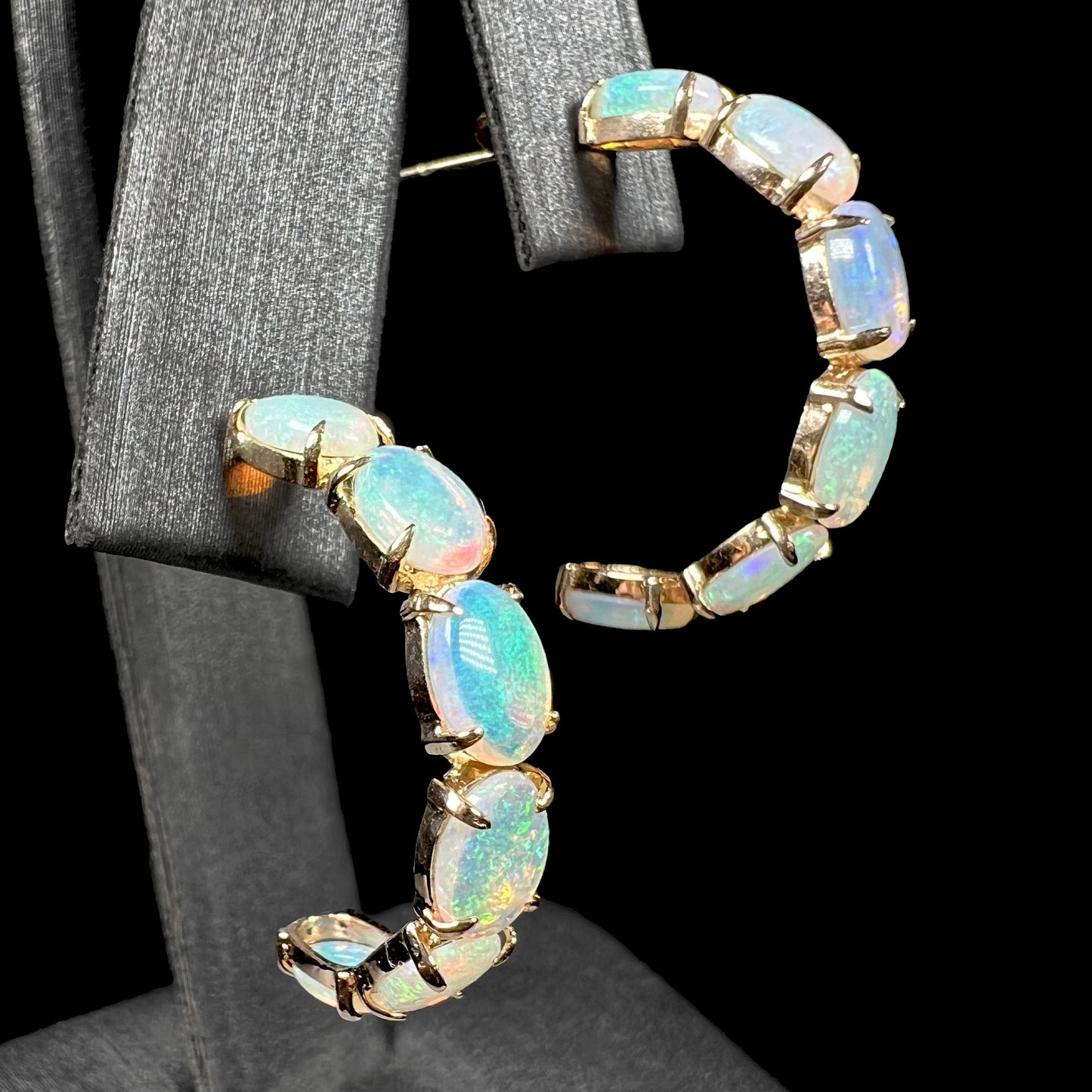 Opposite side angle of crystal opal hoop earrings with visible green and orange fire.