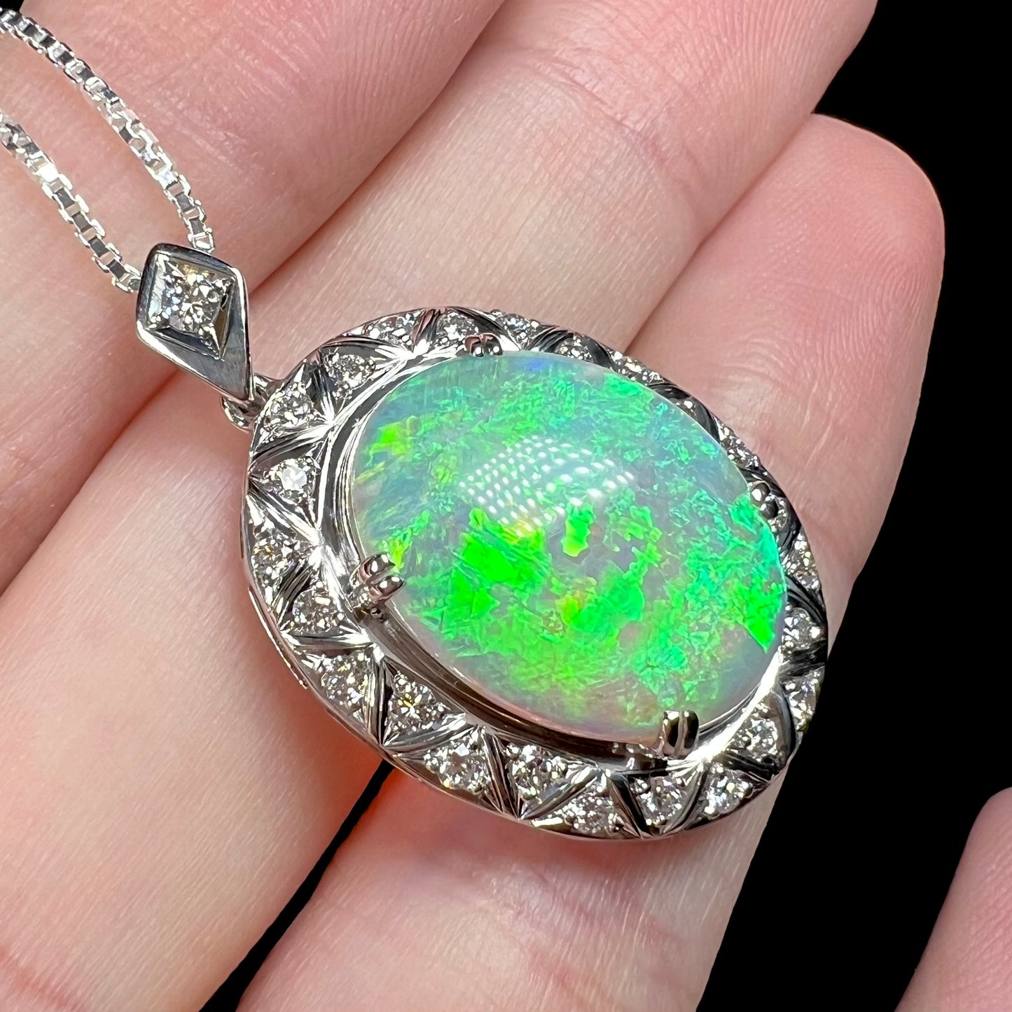 Angled macro shot of crystal opal pendant showing a vibrant green flash.