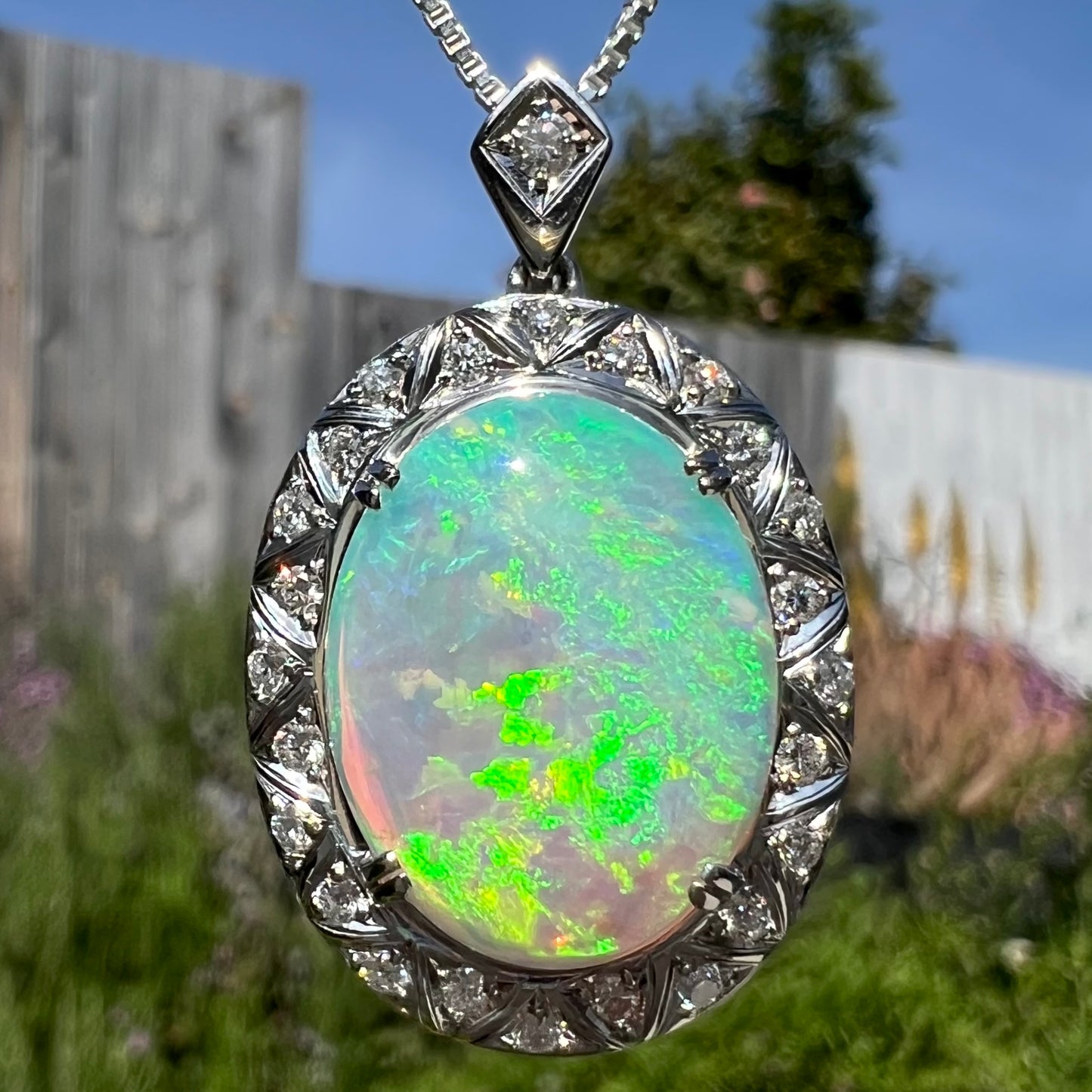 Macro outdoor image of crystal opal necklace in sunlight with green and yellow flashes.