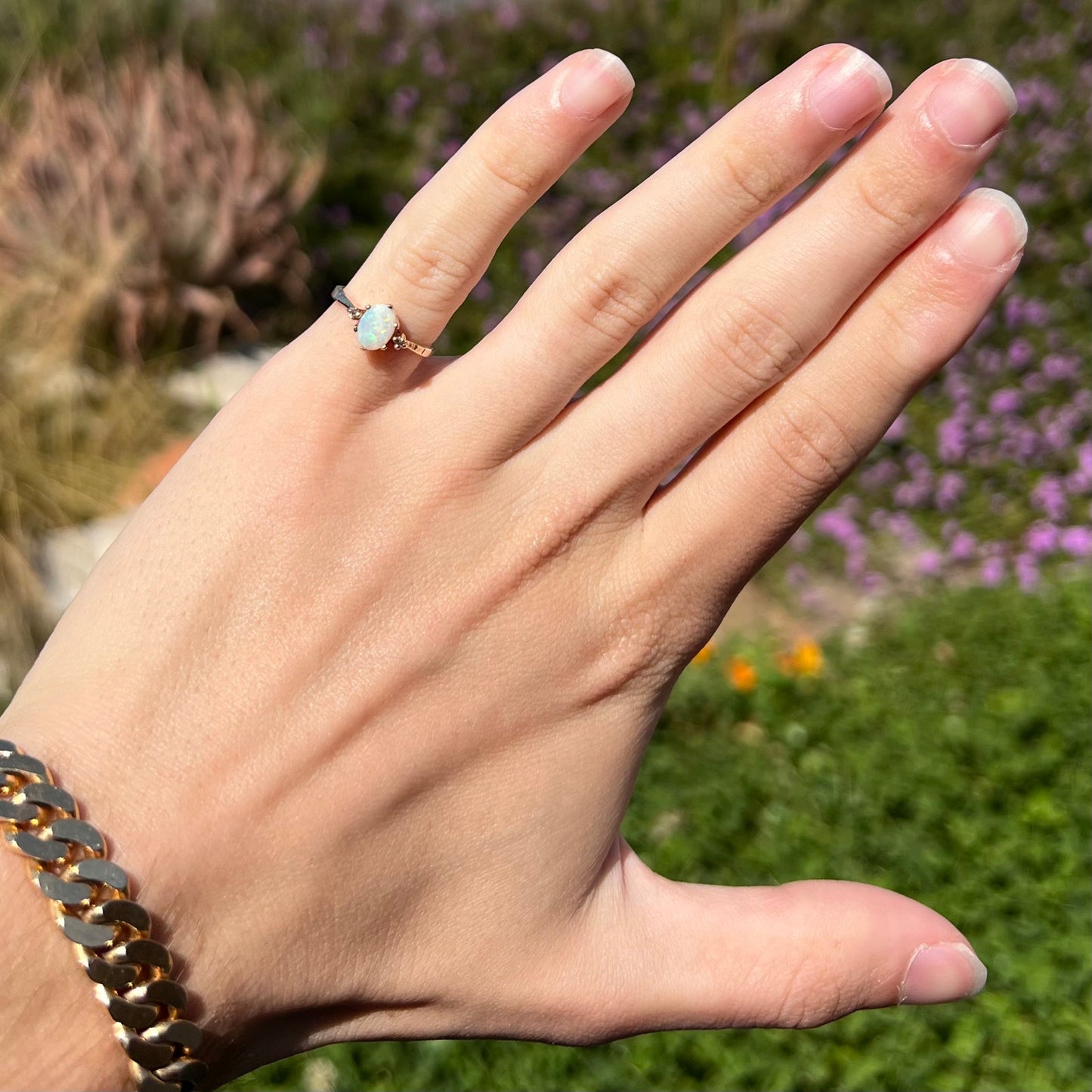 A dainty, 1960's style opal and diamond engagement ring. The ring is prong-set and yellow gold.