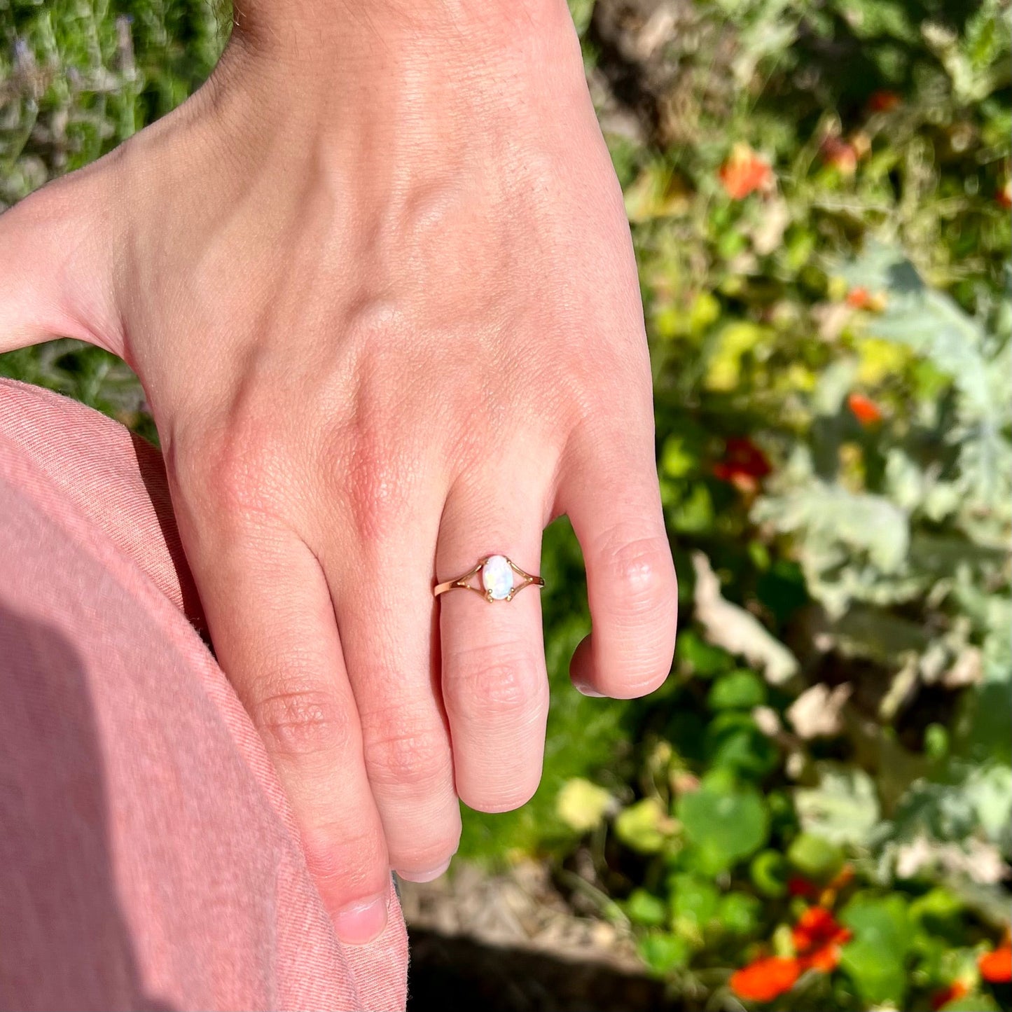 A ladies' simple opal solitaire ring. The ring is yellow gold with a split shank.