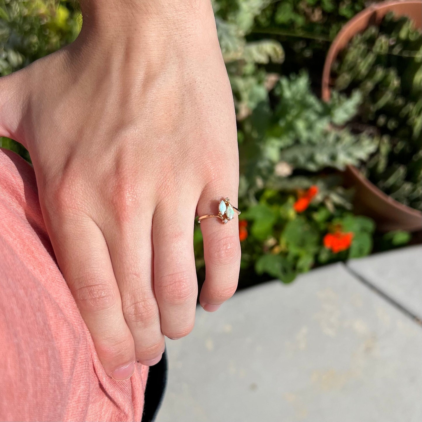 A ladies' gold ring mounted with two marquise cut opals and two diamond accents.
