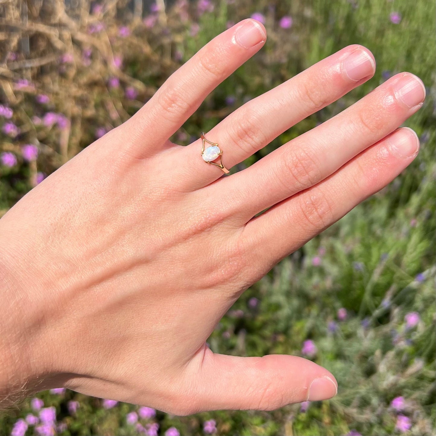 A ladies' simple opal solitaire ring. The ring is yellow gold with a split shank.