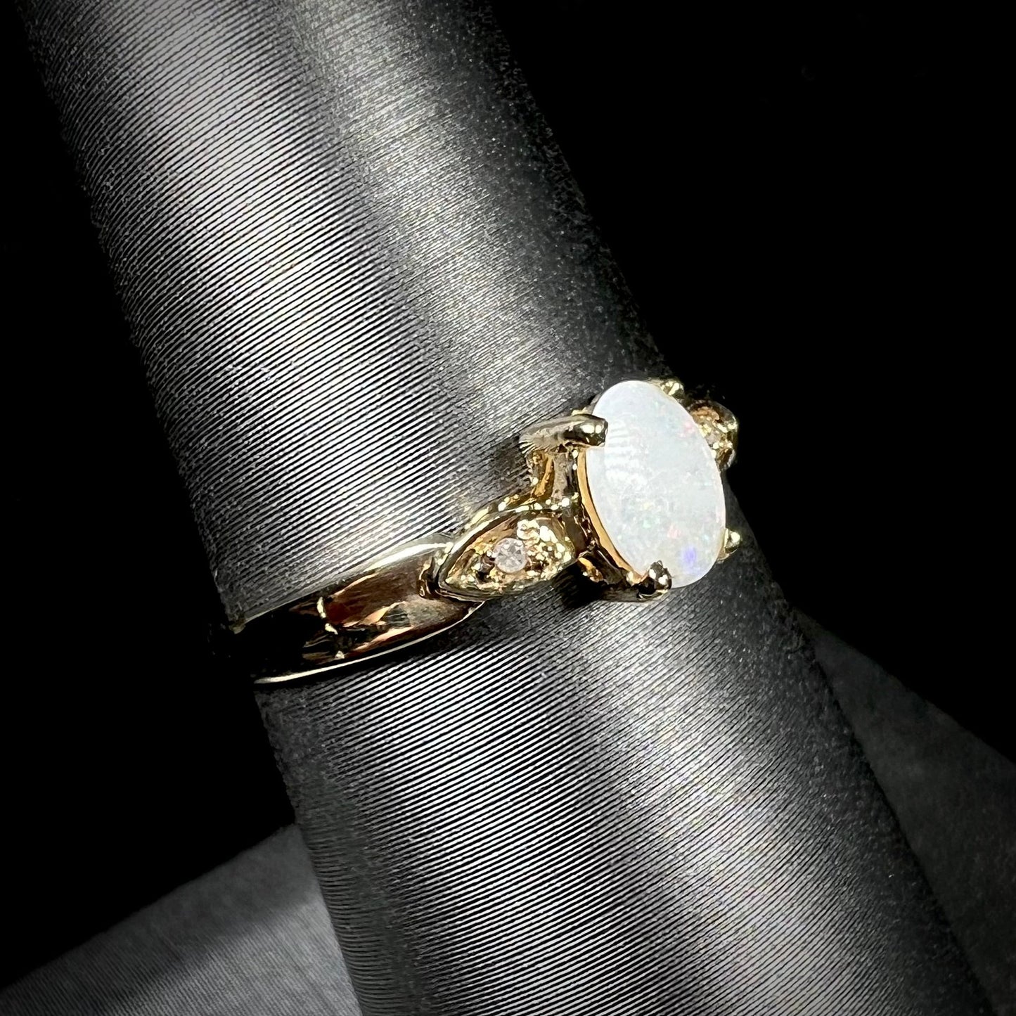 A dainty ladies' yellow gold opal and diamond ring. The opal has subtle play of color.