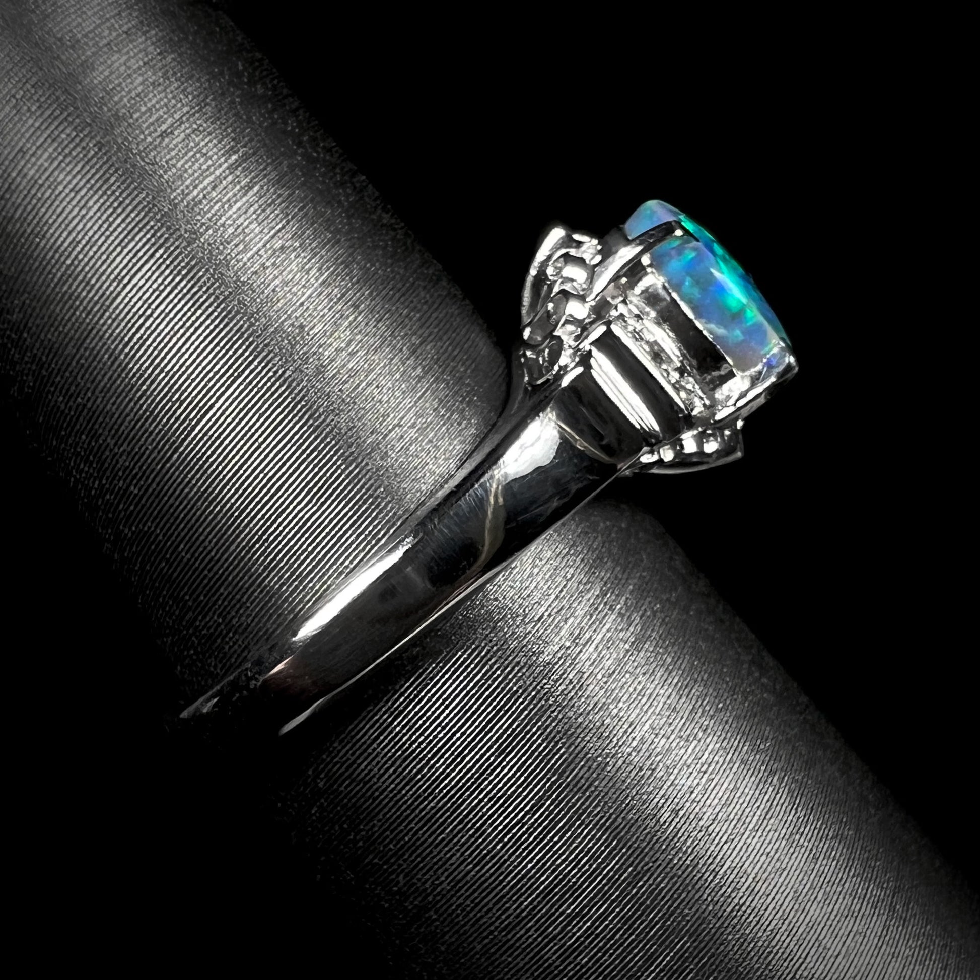 Side view showcasing the delicate shank of a platinum black opal engagement ring.