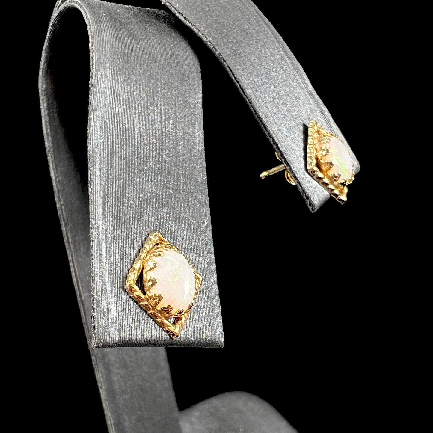 A pair of opal stud earrings. The opals are set in yellow gold diamond shaped mountings.