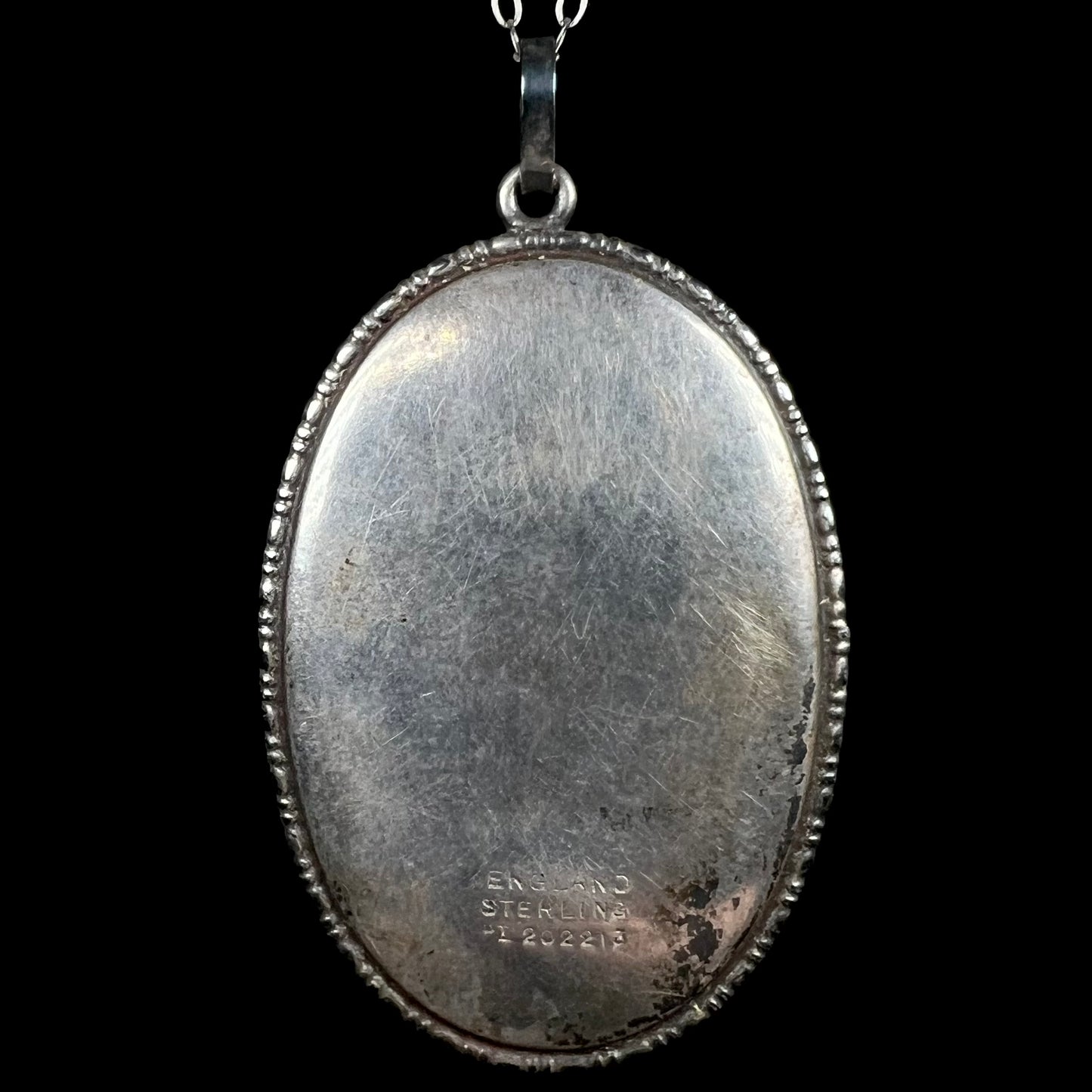 Back of antique silver pendant showing hallmarks "ENGLAND", "STERLING", and "PI202213".