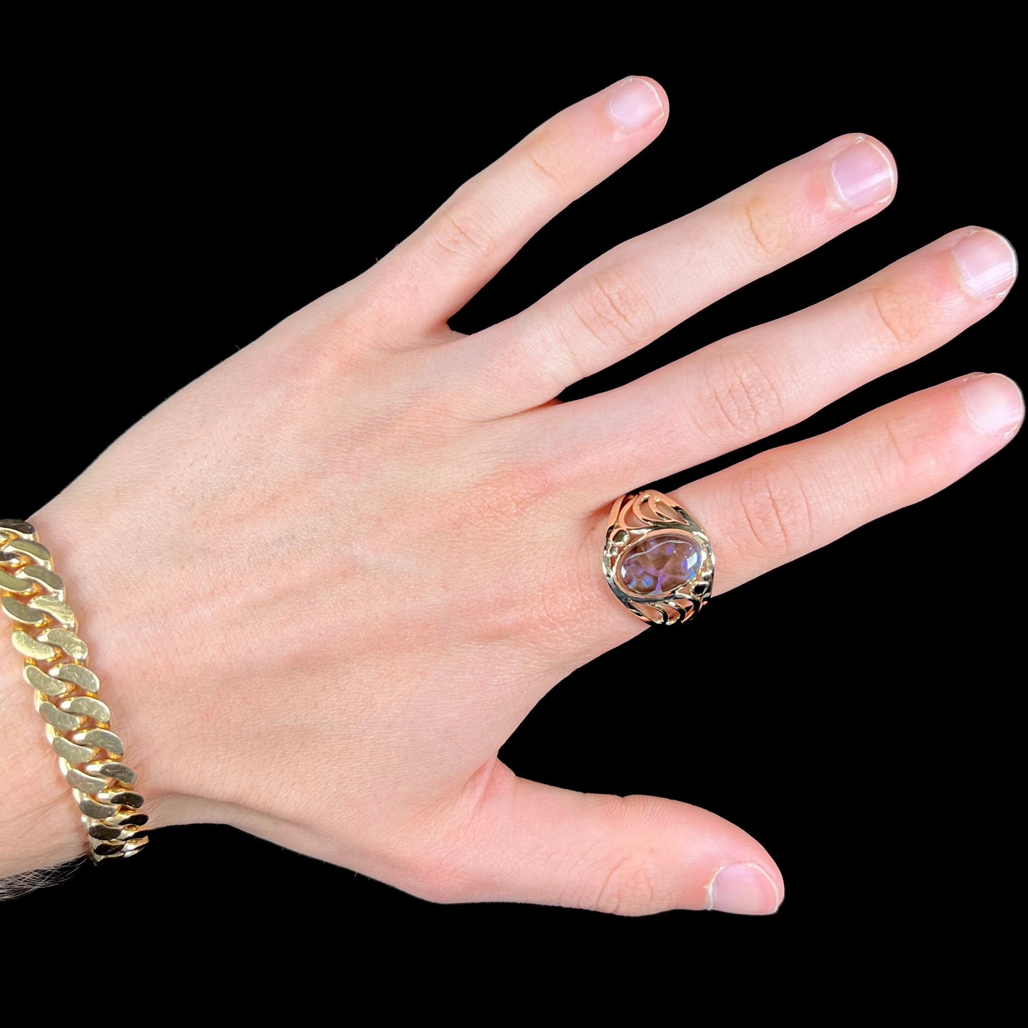 A men's yellow gold fire agate ring. The fire agate is blue and purple with light scratches.