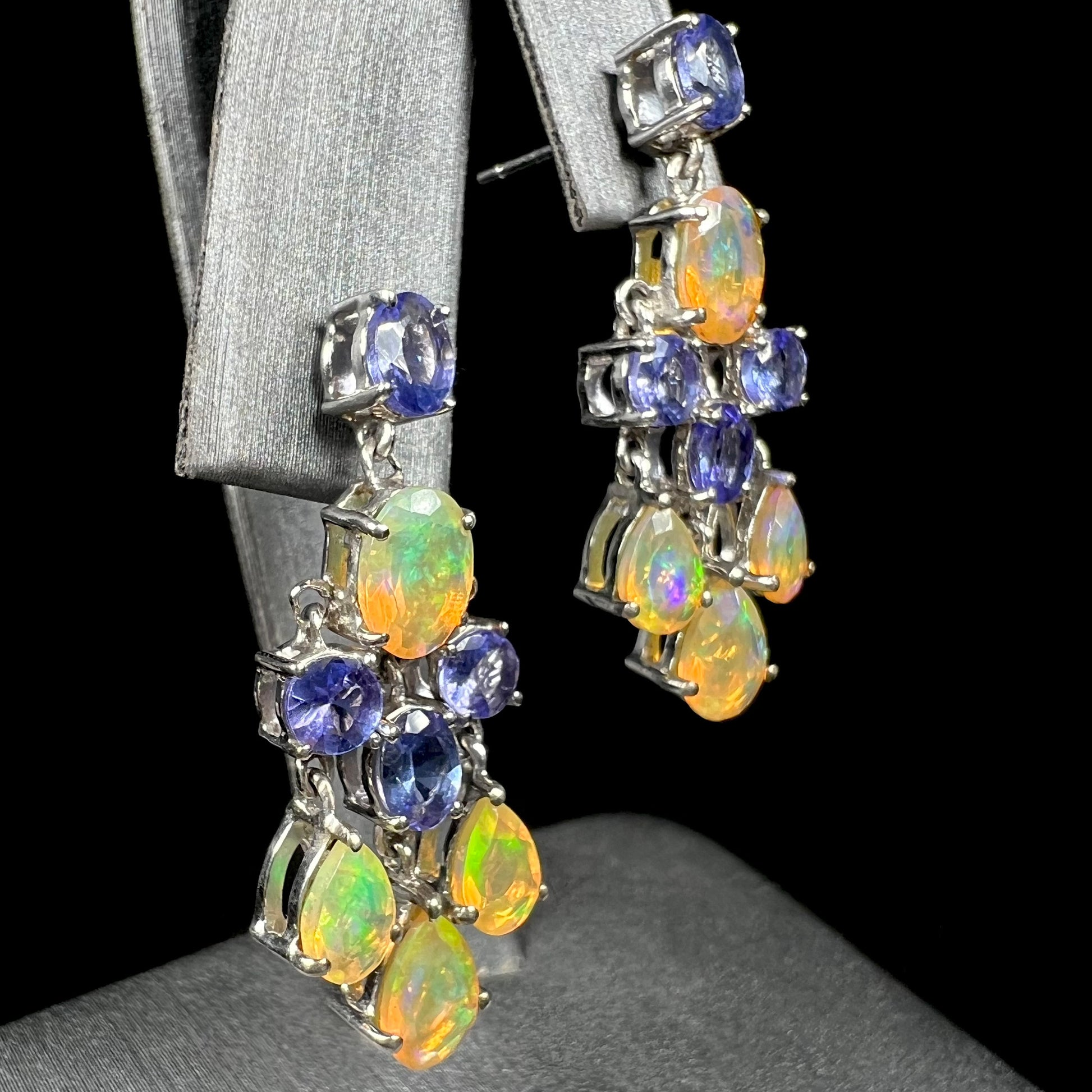A pair of dangling sterling silver Ethiopian opal and tanzanite chandelier earrings.