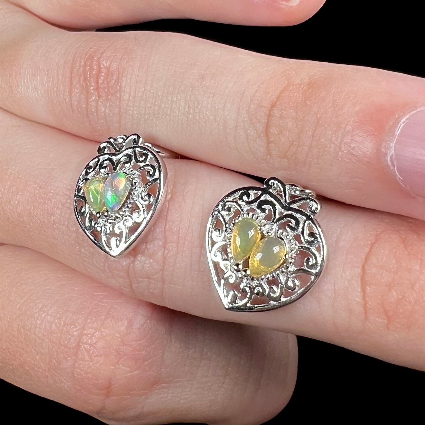 A pair of dangling sterling silver filigree heart earrings, each set with two Ethiopian opals.