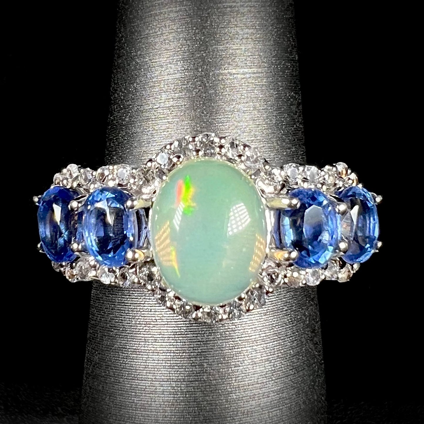 Front straight view of Ethiopian opal and blue kyanite ring, surrounded by a halo of white topaz.
