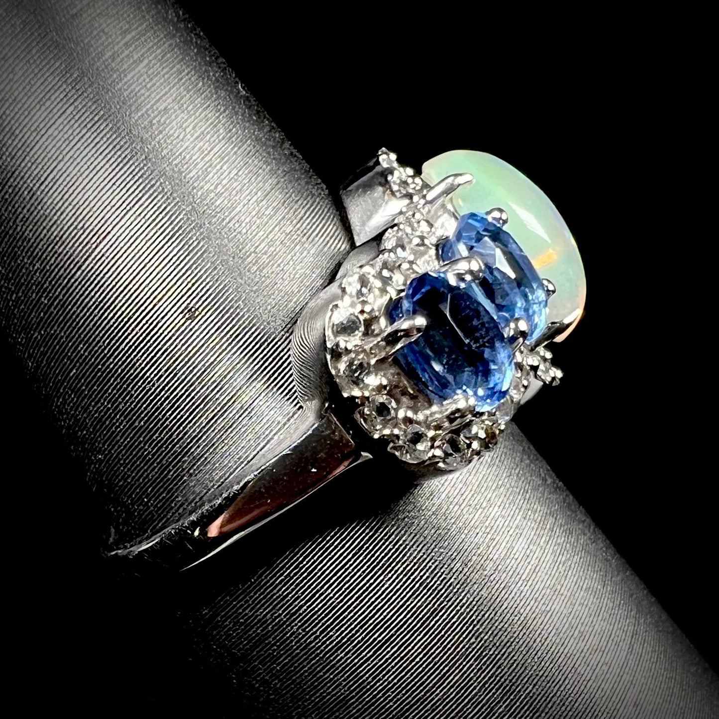 Side view of an Ethiopian opal and kyanite ring. The ring's shank is mostly in view.