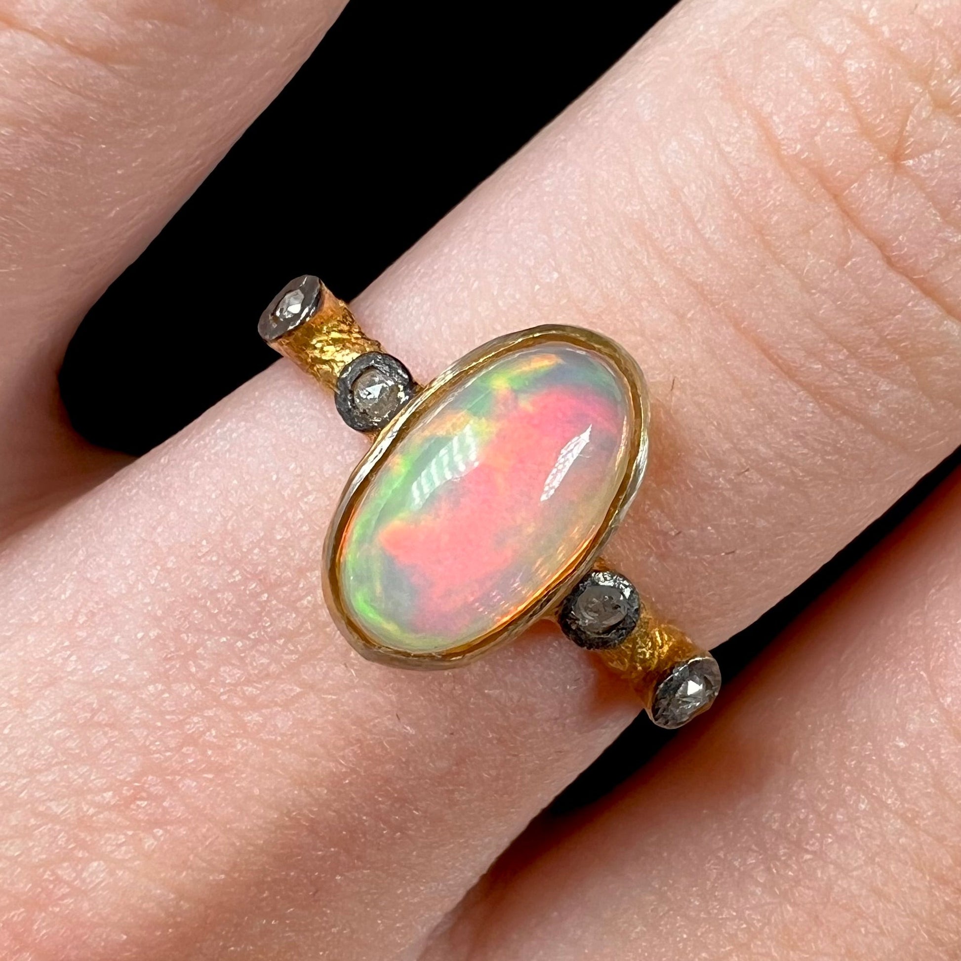 A yellow gold plated sterling silver ring mounted with an Ethiopian fire opal and rose cut diamond accents.
