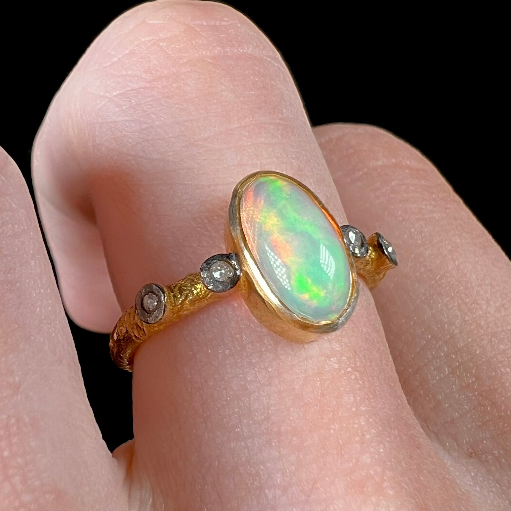 A yellow gold plated sterling silver ring mounted with an Ethiopian fire opal and rose cut diamond accents.