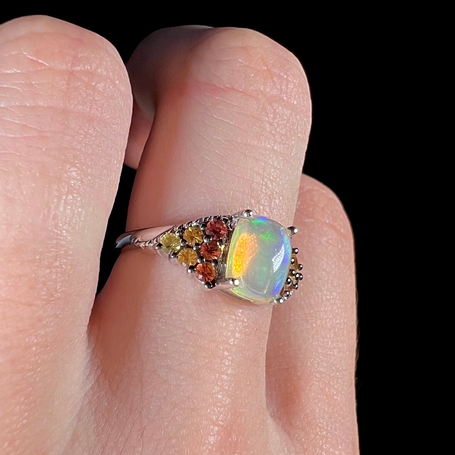 A ladies' silver ring set with a cushion cabochon cut Ethiopian fire opal stone and citrine accents.