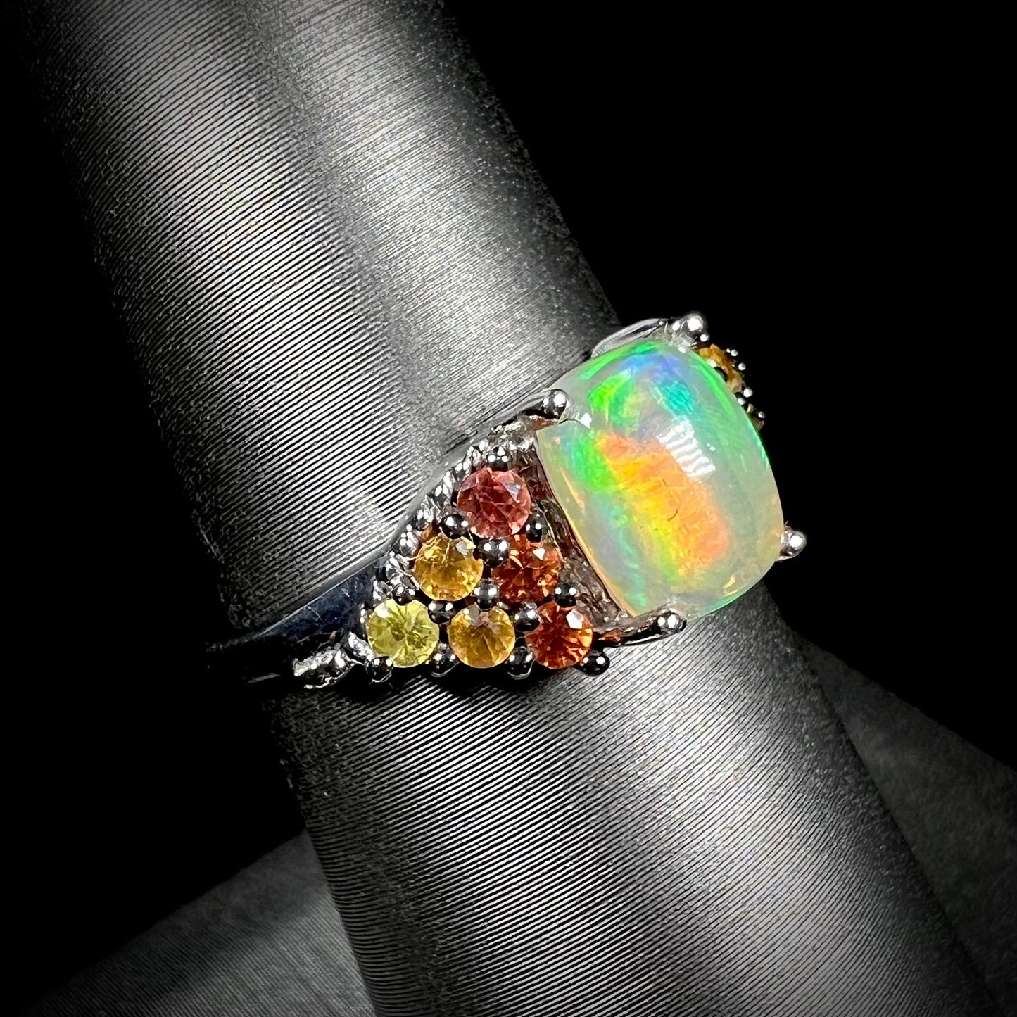 A ladies' silver ring set with a cushion cabochon cut Ethiopian fire opal stone and citrine accents.