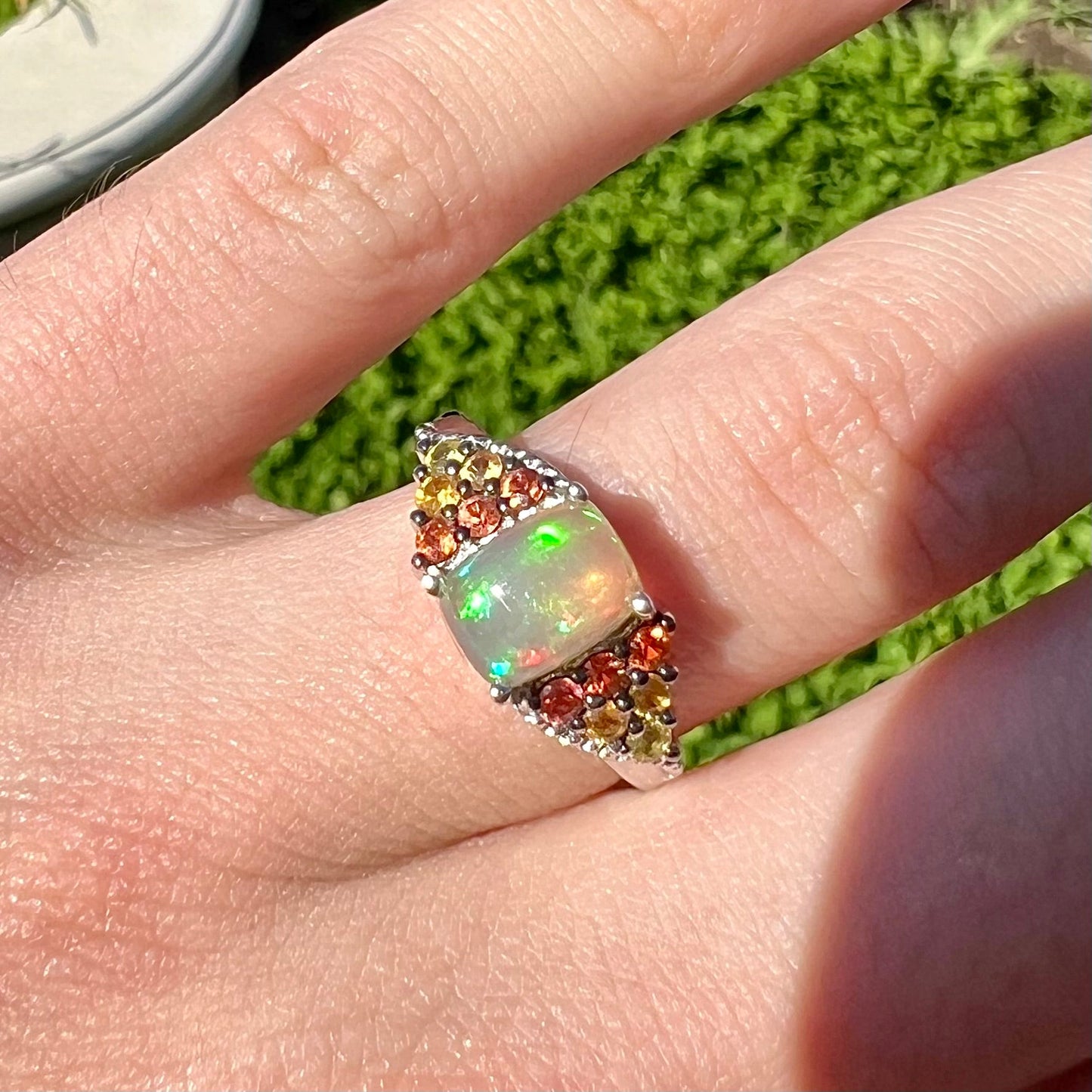A ladies' silver ring set with a cushion cabochon cut Ethiopian fire opal stone and citrine accents.