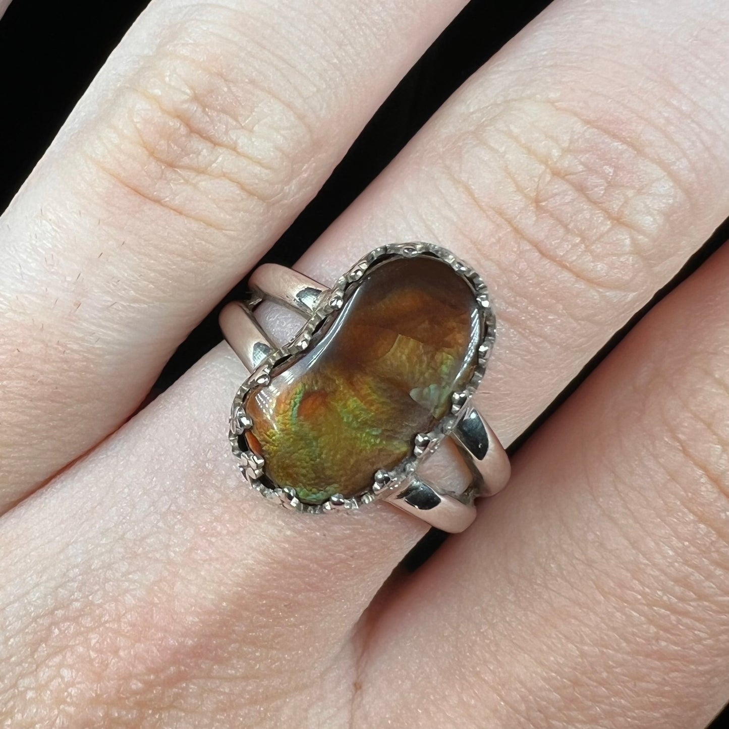 Close-up front view of hand wearing a silver fire agate ring.