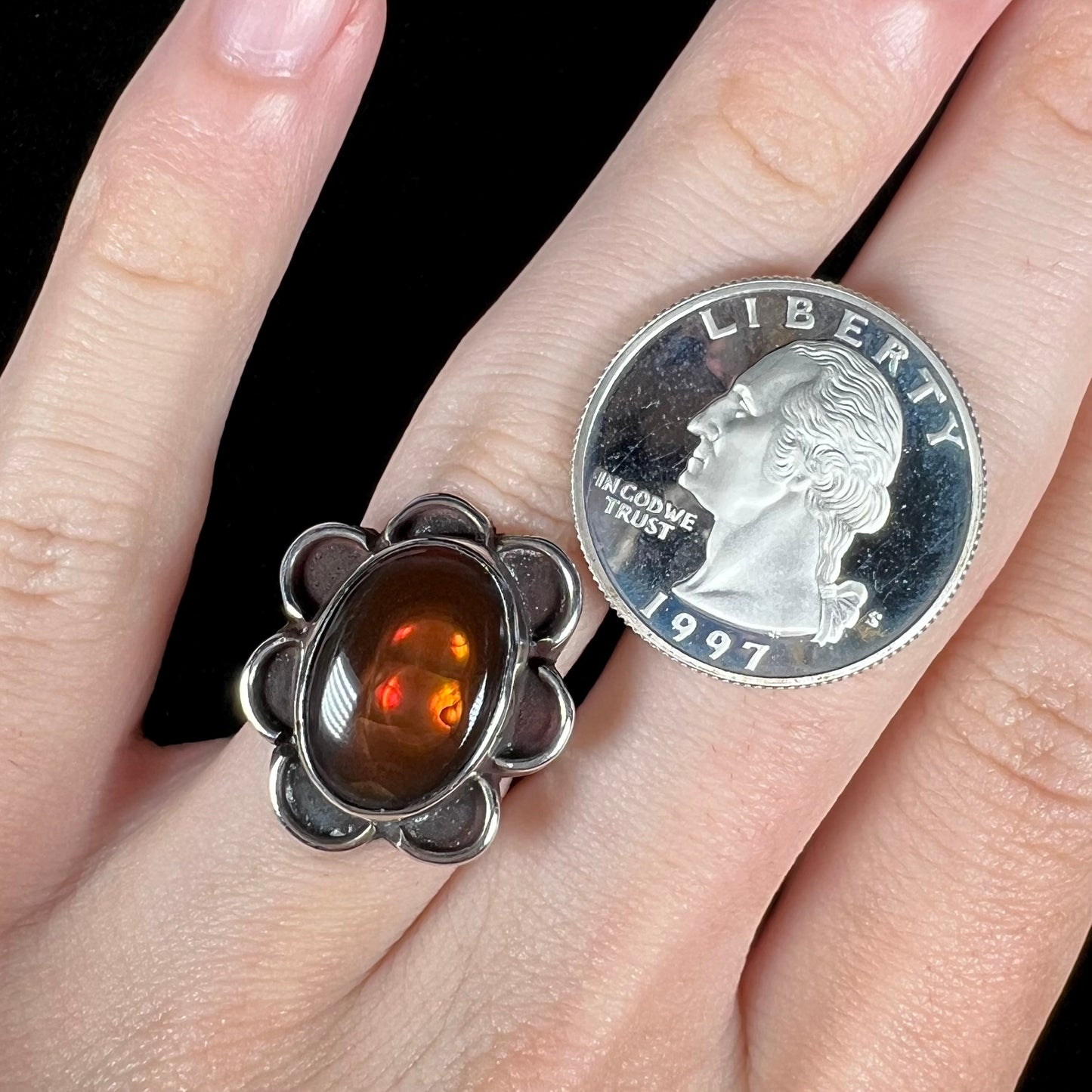 Fire agate ring on hand with US quarter for size reference.
