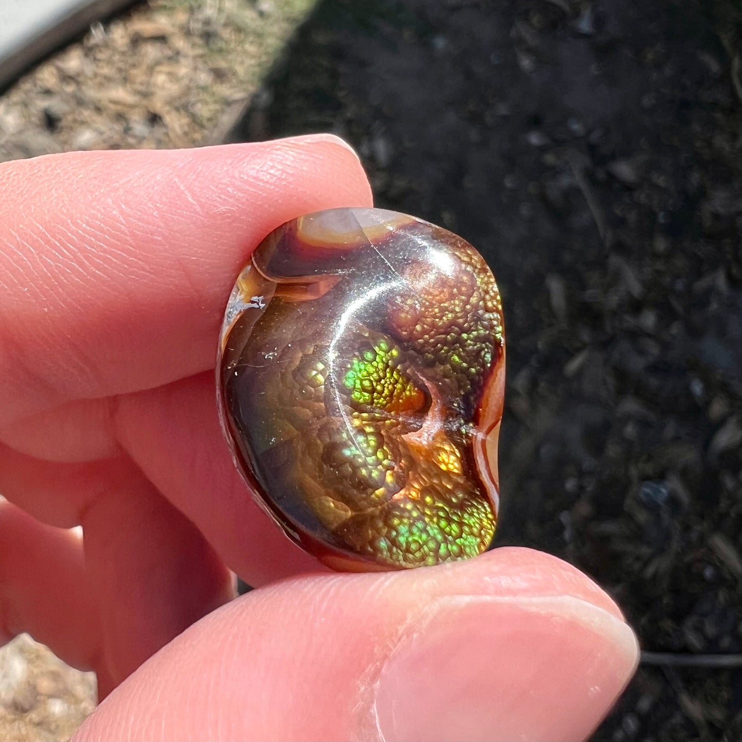 A large Mexican fire agate cabochon. The stone has a bubbly green pattern.