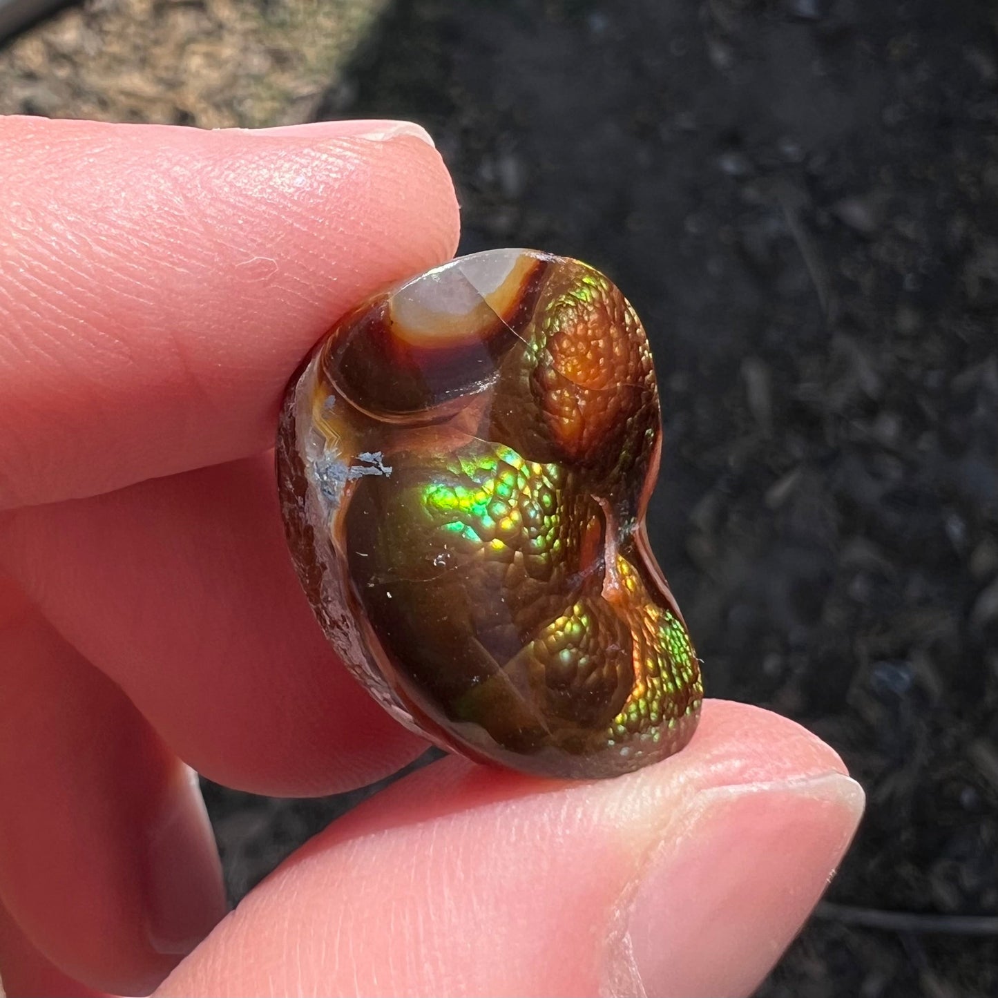 A large Mexican fire agate cabochon. The stone has a bubbly green pattern.