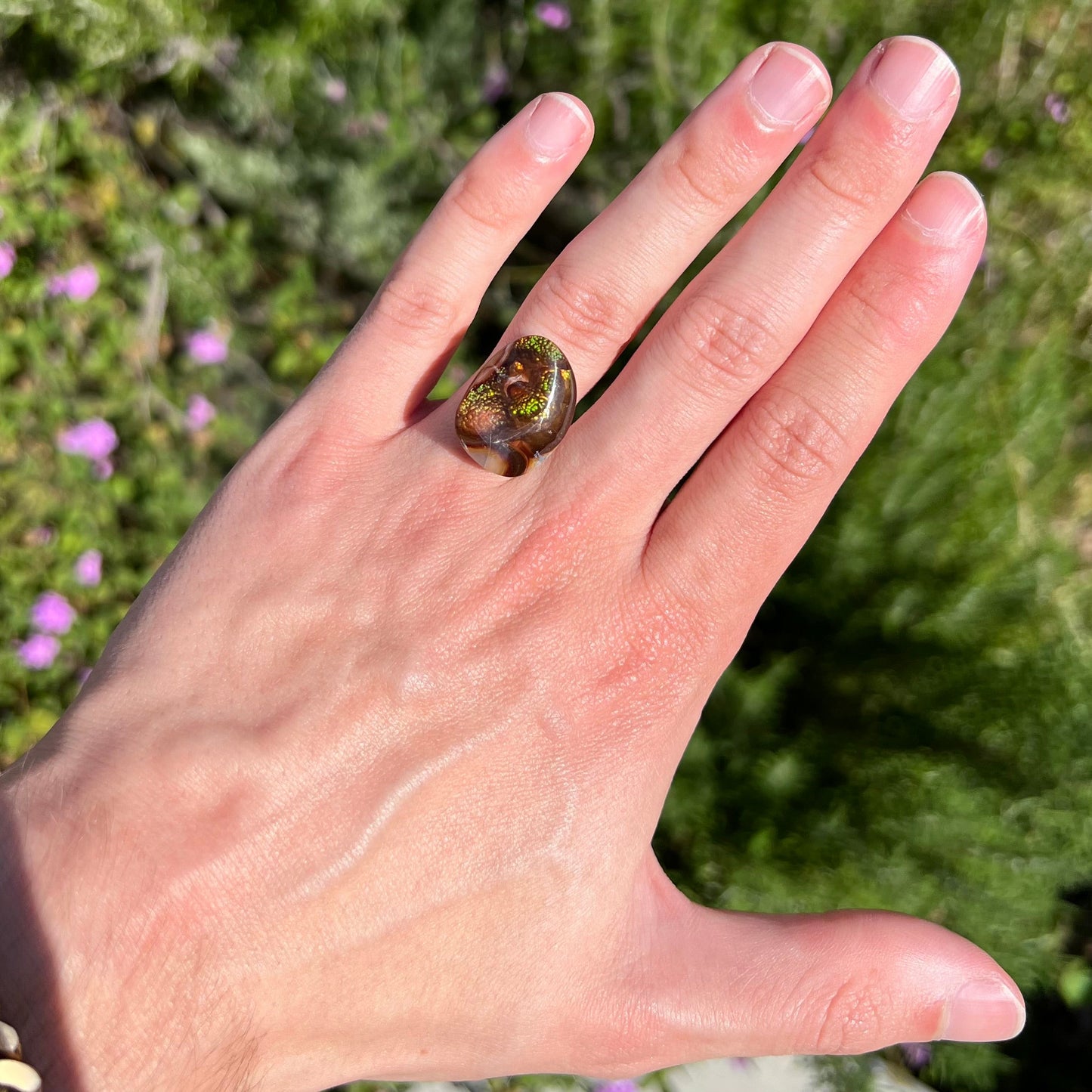 A large Mexican fire agate cabochon. The stone has a bubbly green pattern.