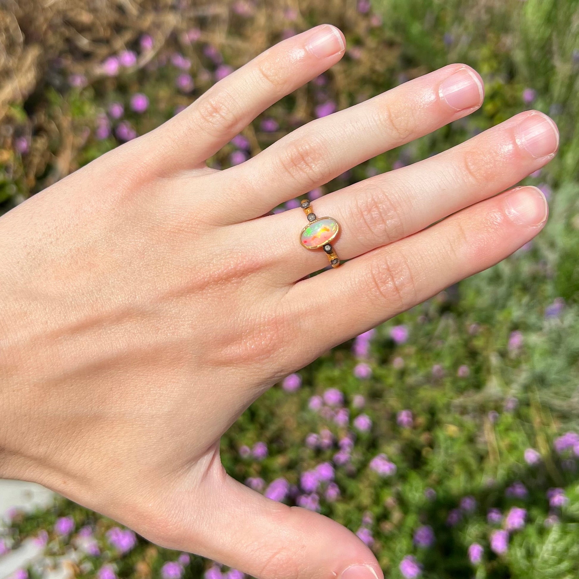 A yellow gold plated sterling silver ring mounted with an Ethiopian fire opal and rose cut diamond accents.