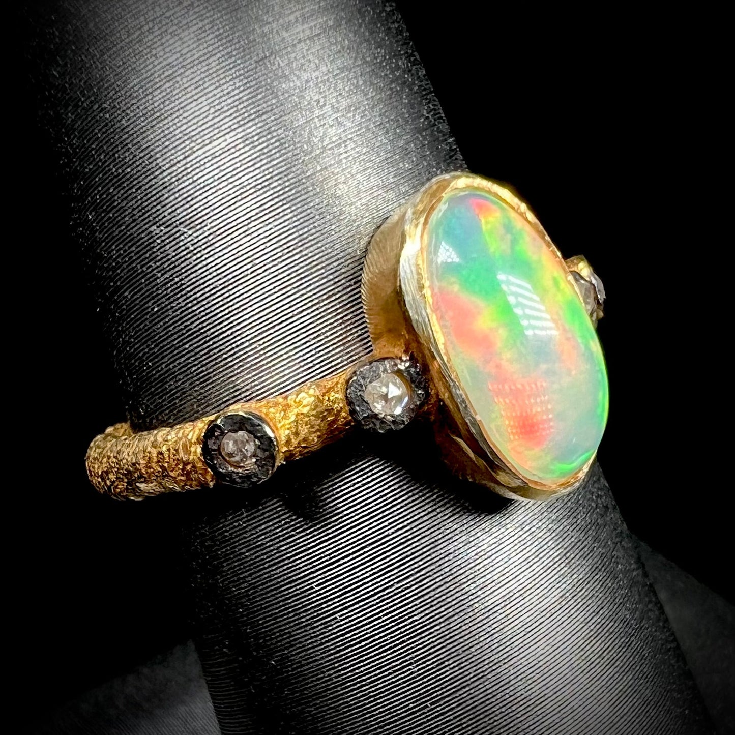 A yellow gold plated sterling silver ring mounted with an Ethiopian fire opal and rose cut diamond accents.