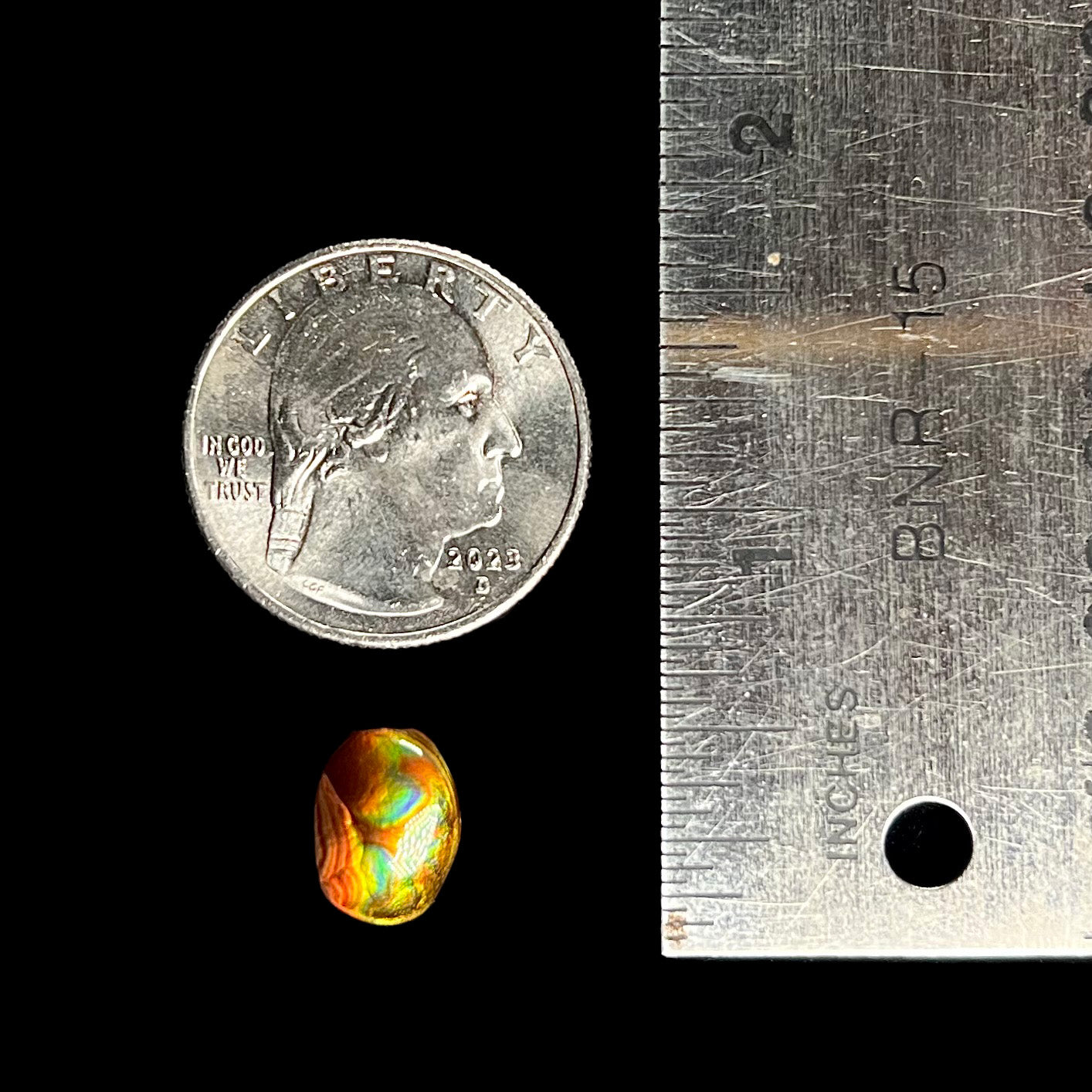 A loose, imperial grade Mexican fire agate gemstone. The stone brightly glows every color in the sunlight.