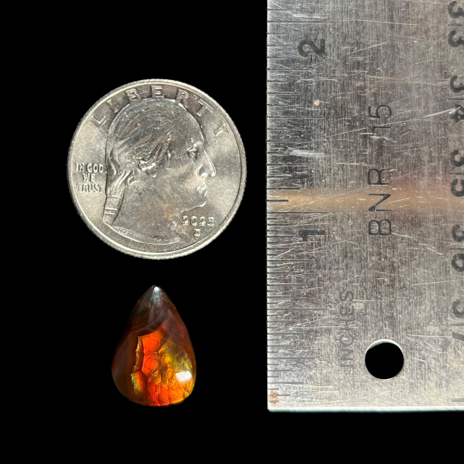 A loose, pear shaped Mexican fire agate gemstone.  The stone is predominantly vivid red with green overtones.
