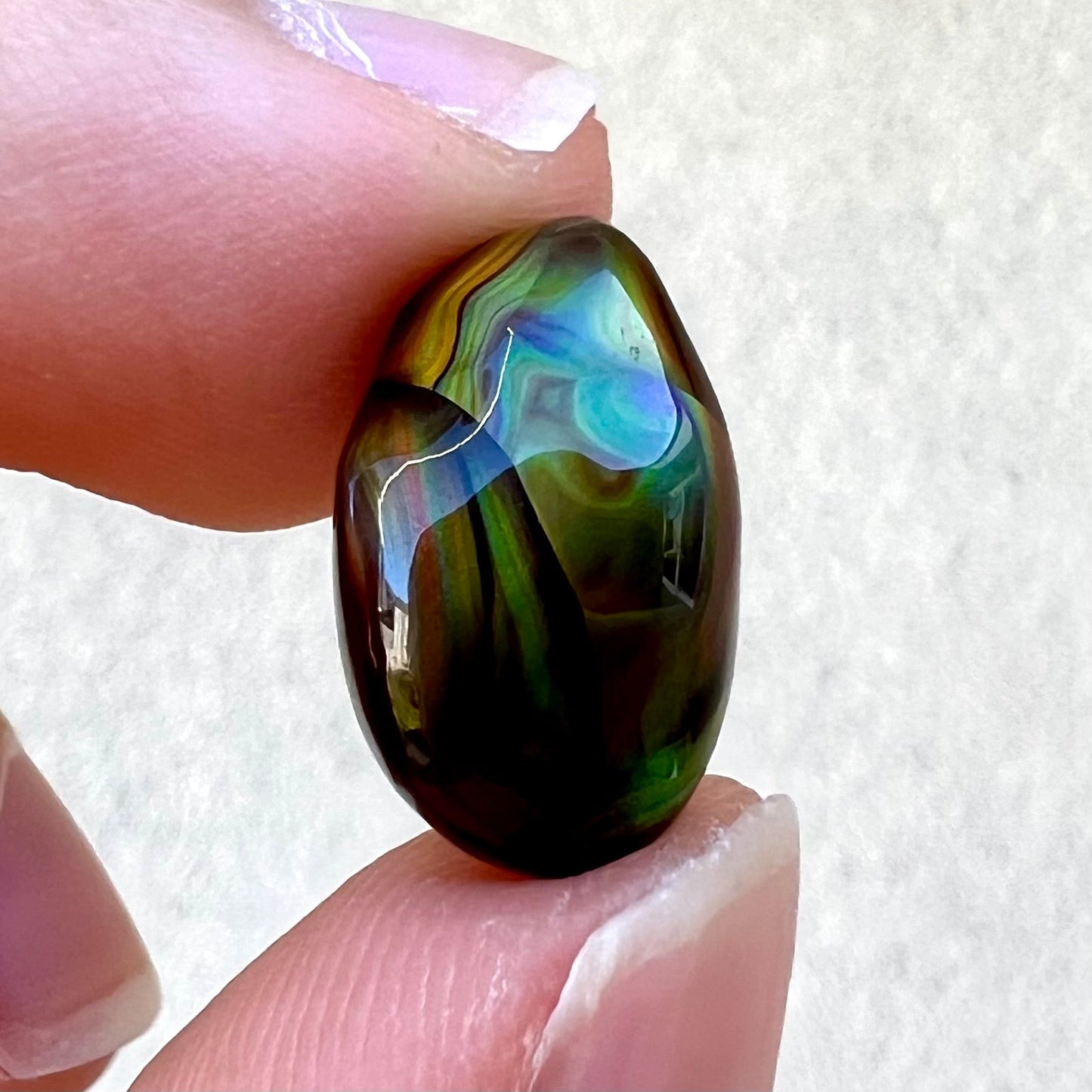 A loose, gem grade Mexican fire agate stone.  The stone is finely banded and ice blue green color.